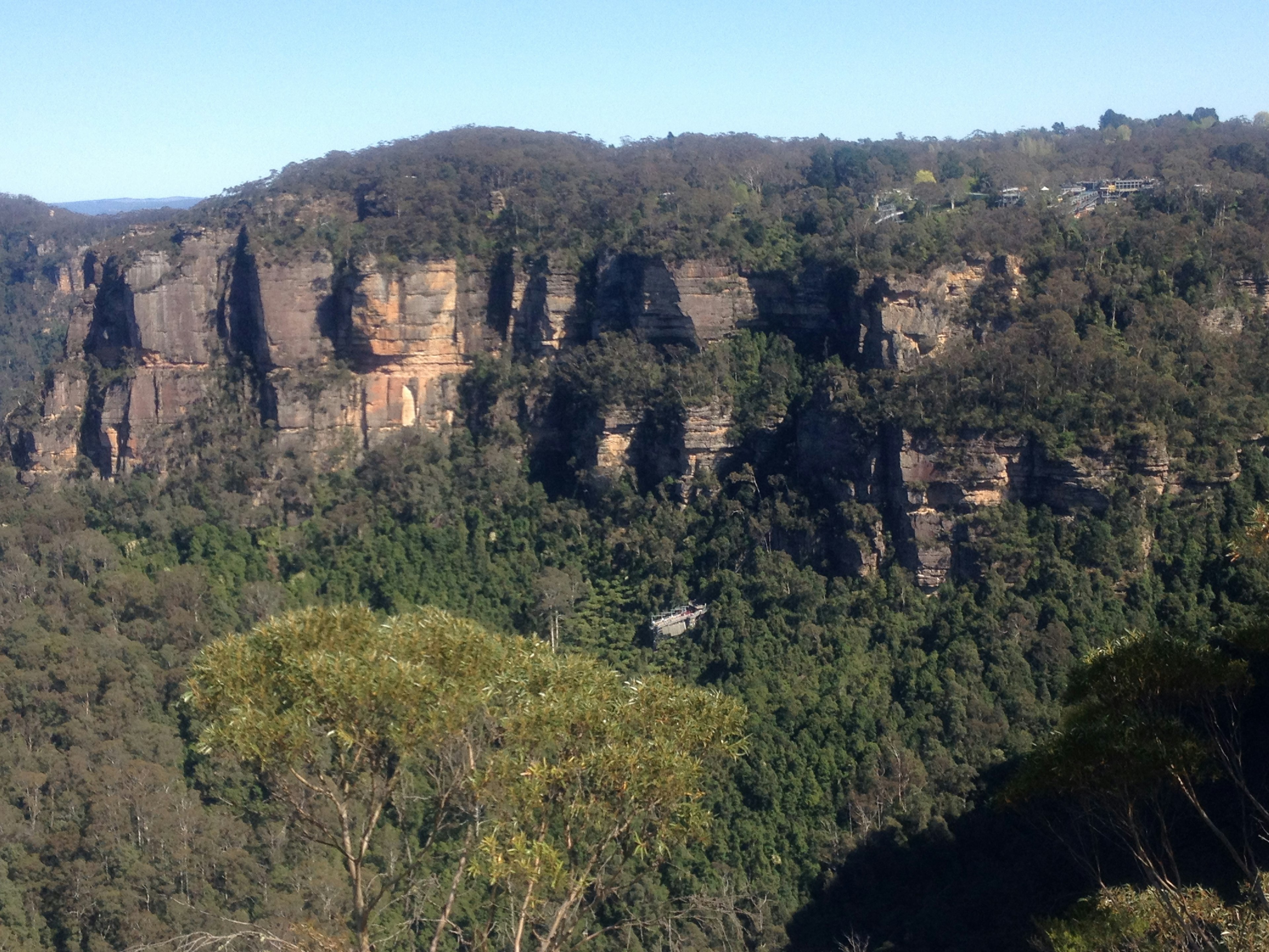 Scenic view of towering cliffs surrounded by lush greenery