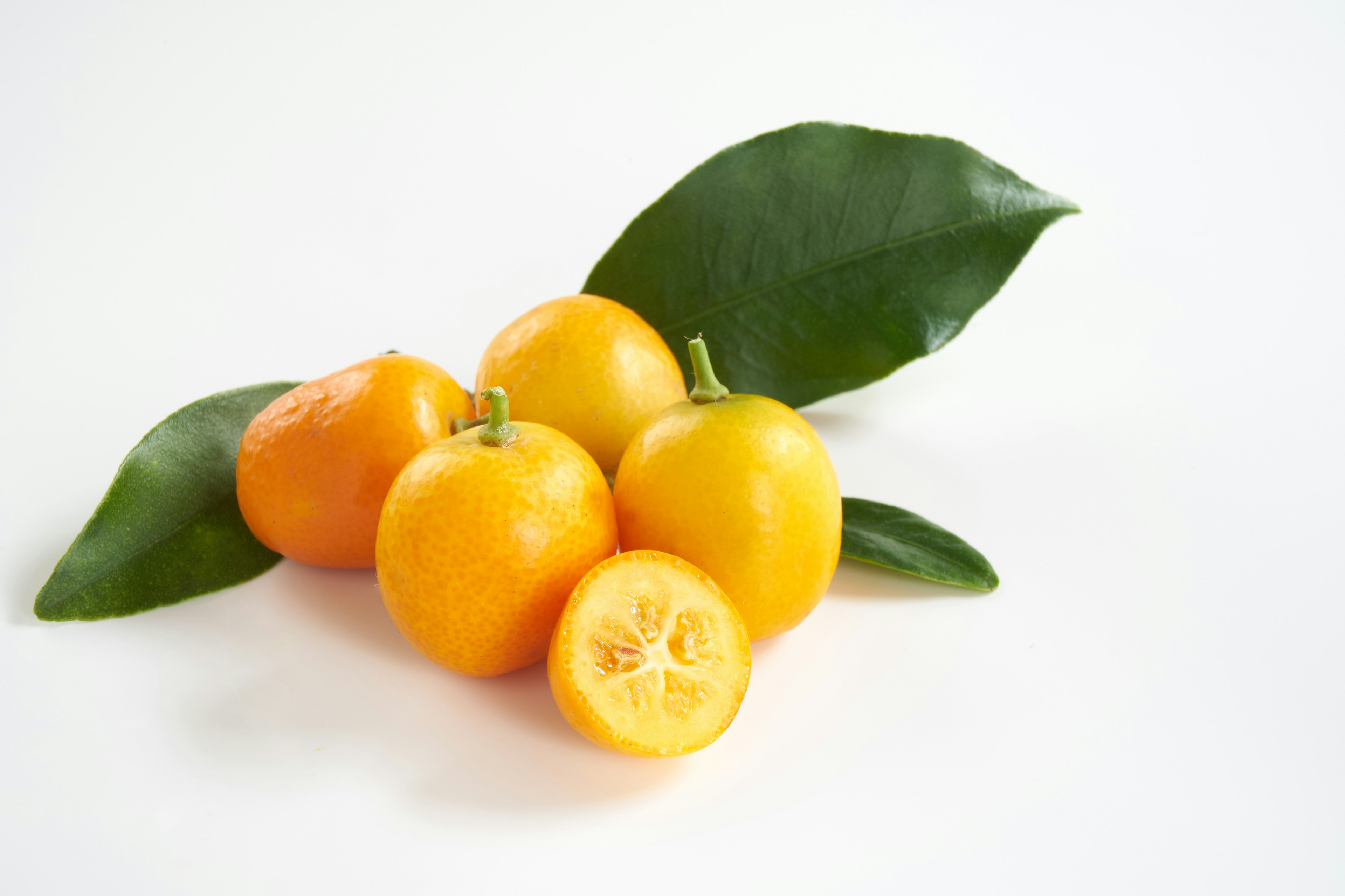 Arreglo de frutas naranjas vibrantes con hojas verdes