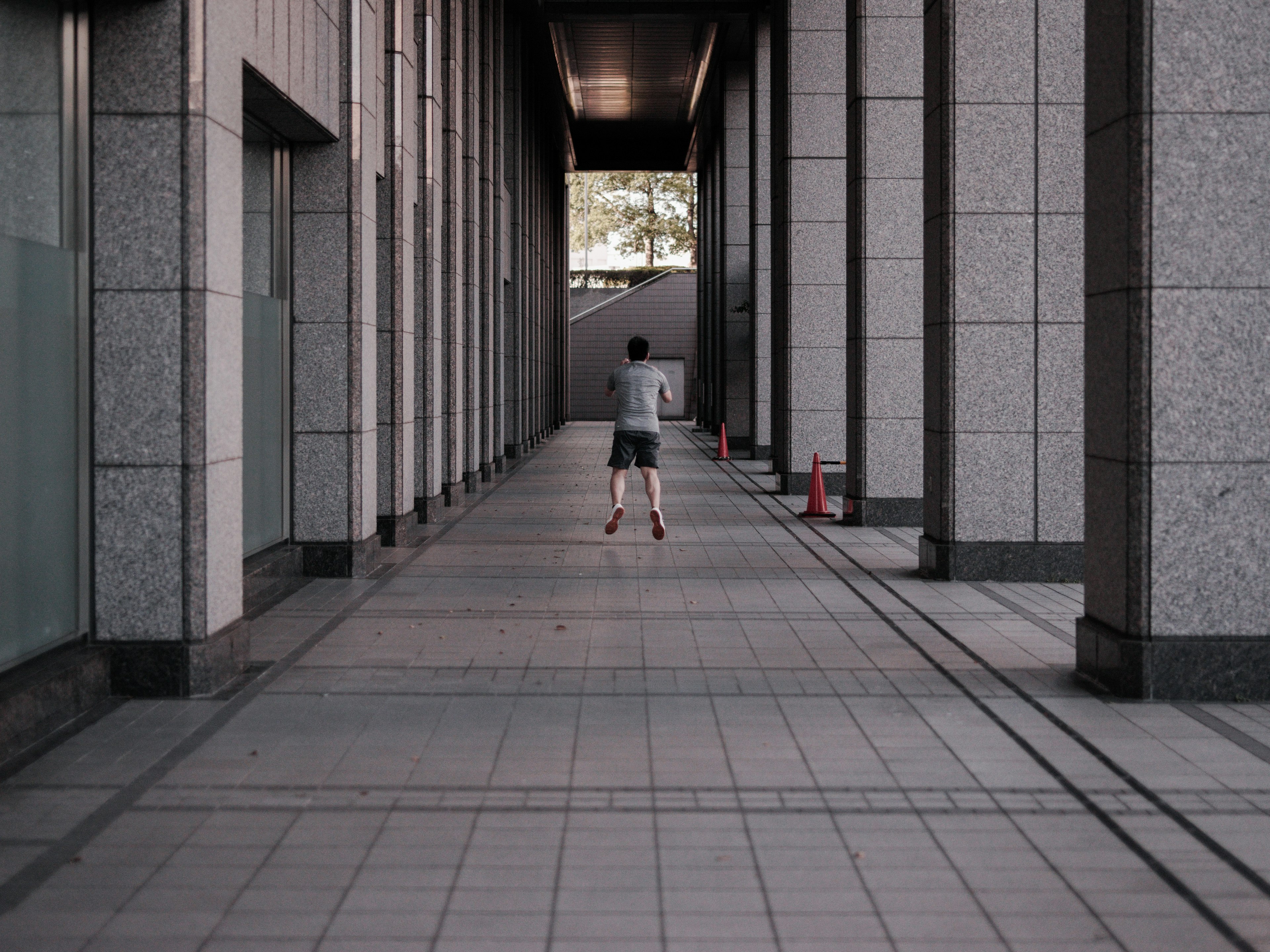 A person walking in a long corridor with modern architecture