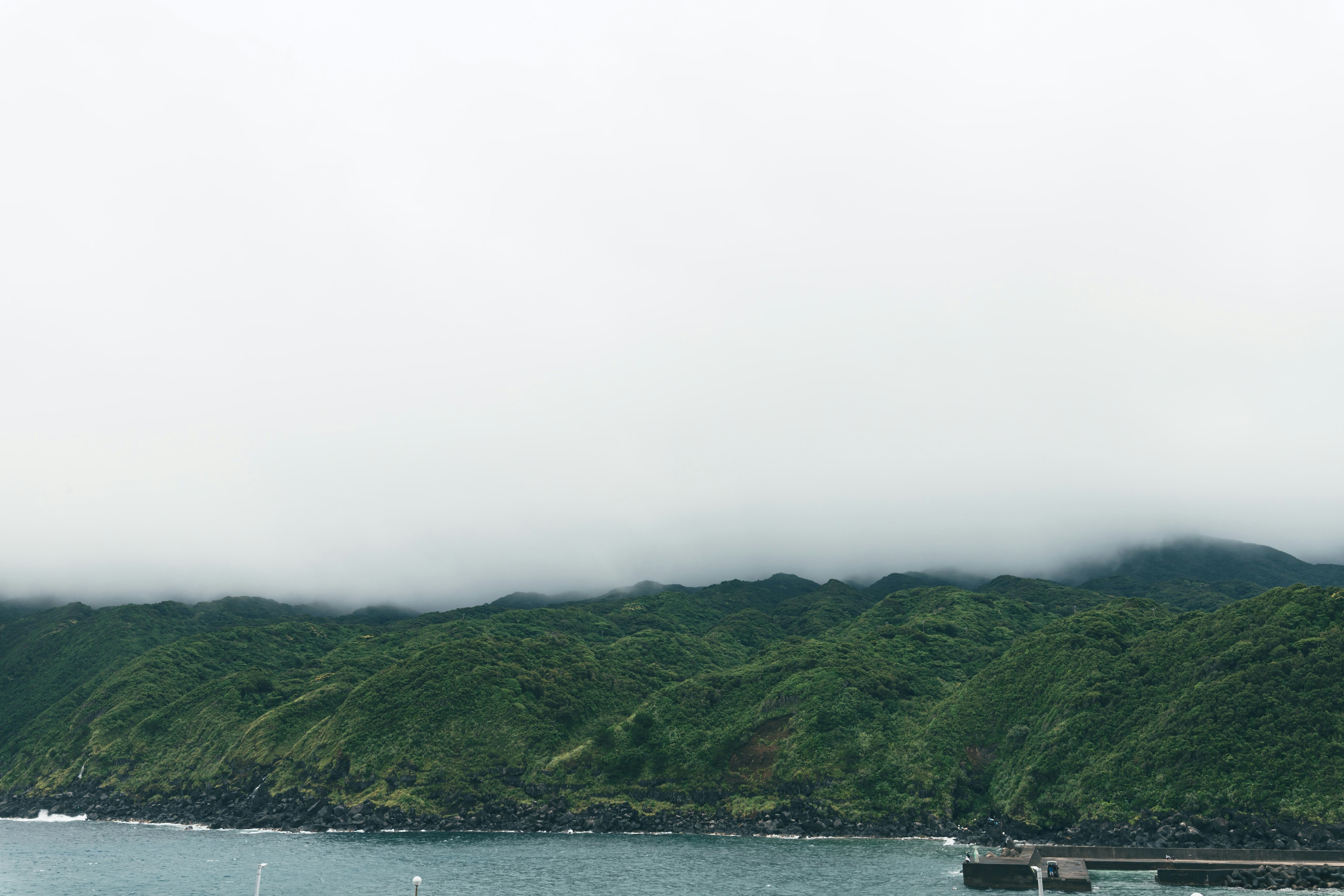 海と緑の山々が広がる霧のかかった風景