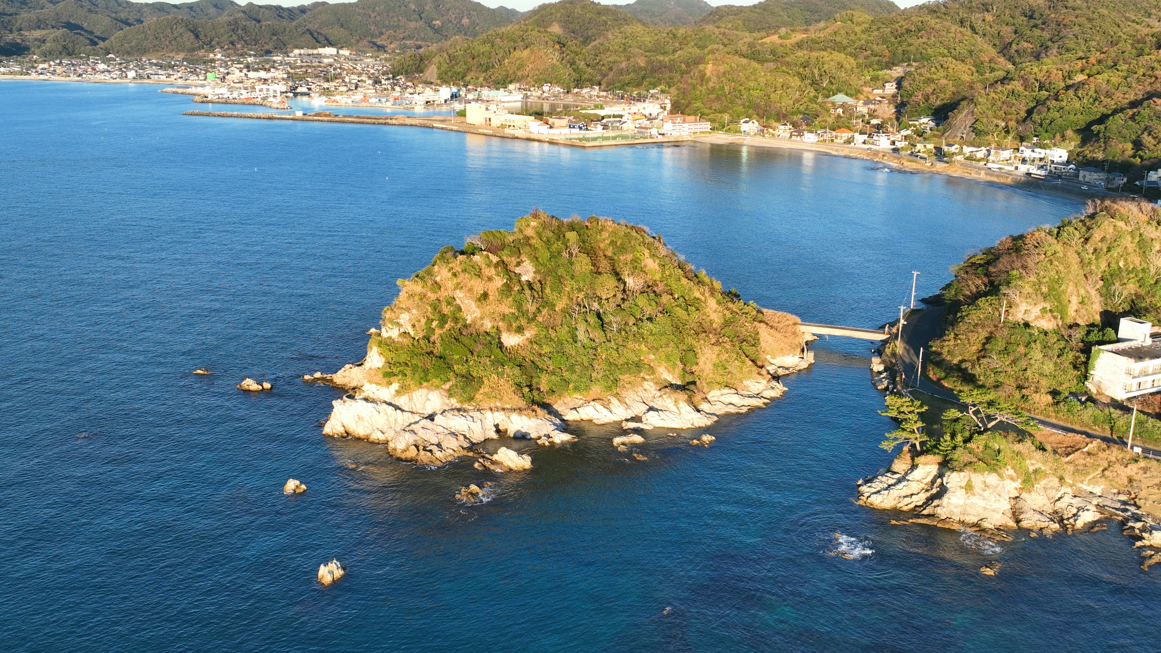 Pemandangan indah dengan pulau-pulau di tengah laut biru dan bukit hijau