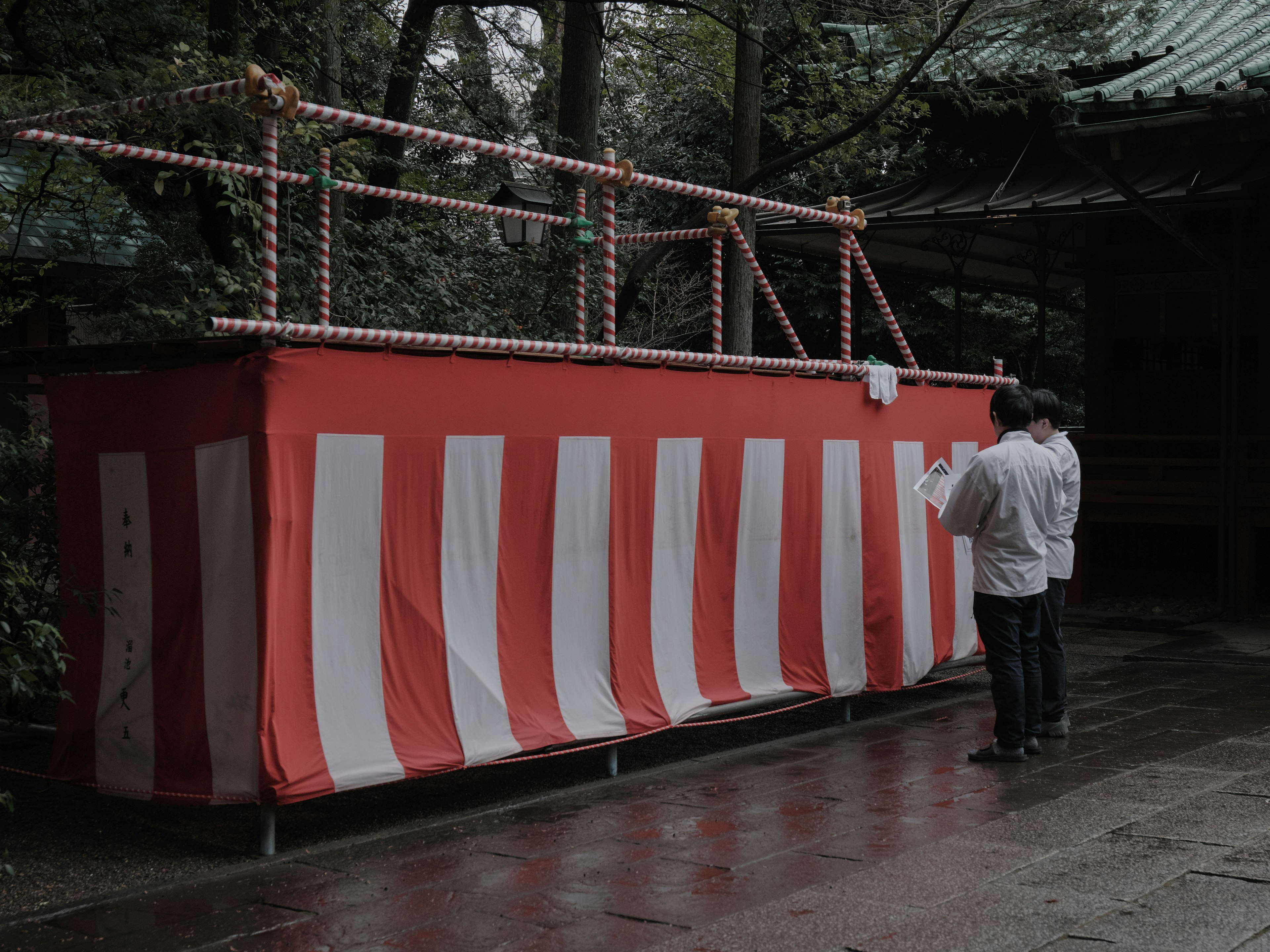 Scene featuring a red and white striped tent with a person standing nearby