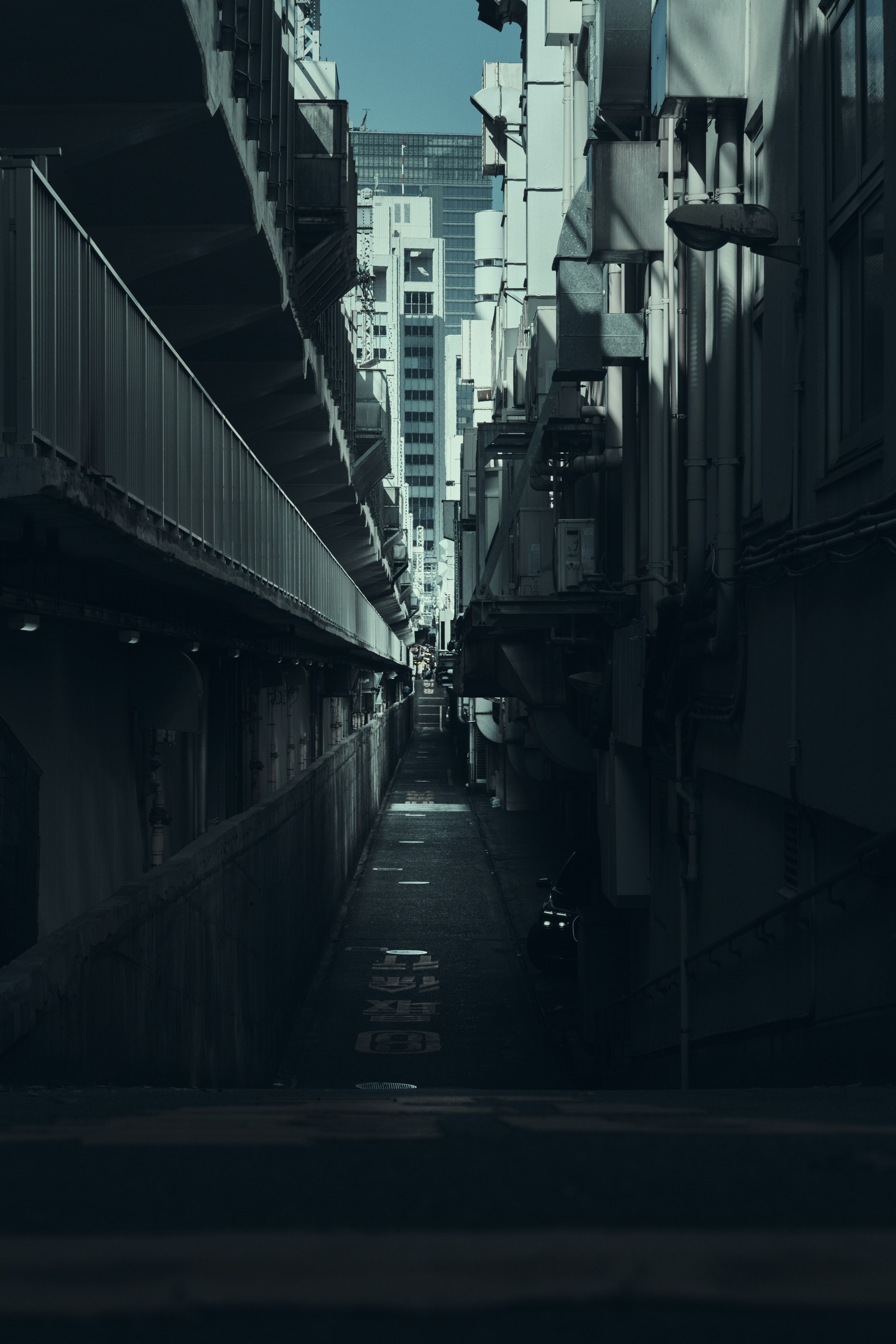 Narrow alleyway photograph with tall buildings on both sides leading into the distance