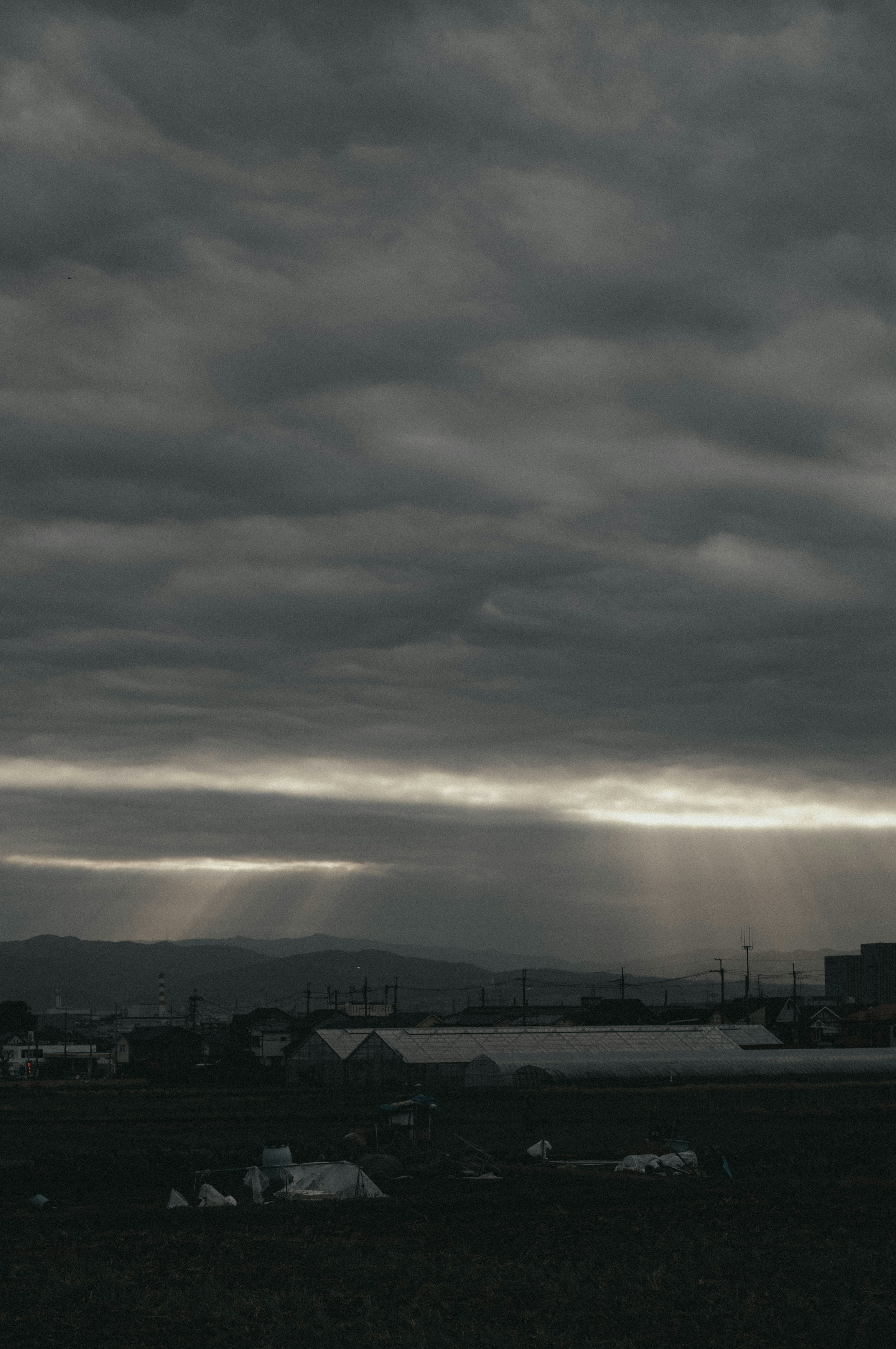 Cielo nublado oscuro con silueta de montañas