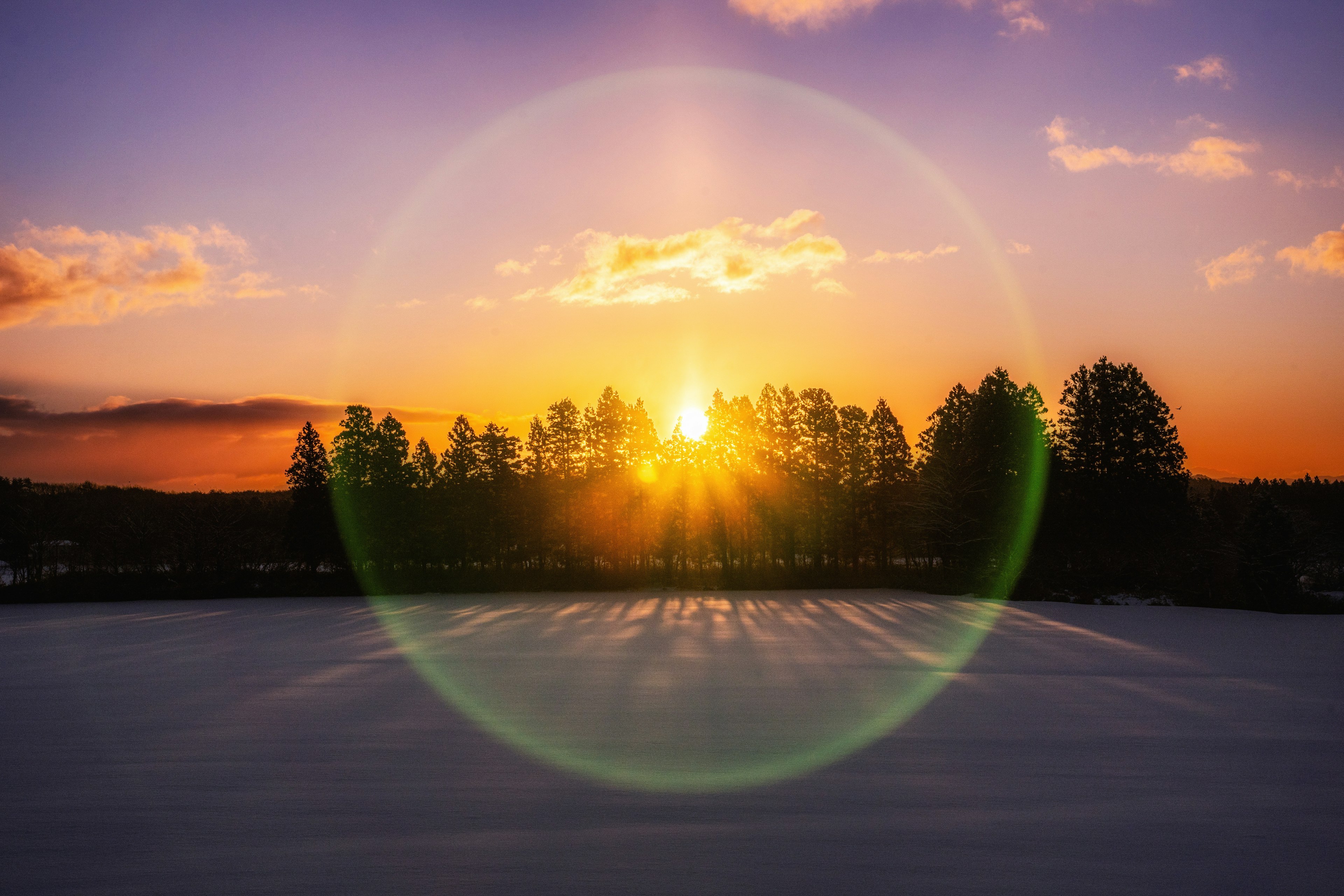 Snow-covered landscape with a beautiful sunset