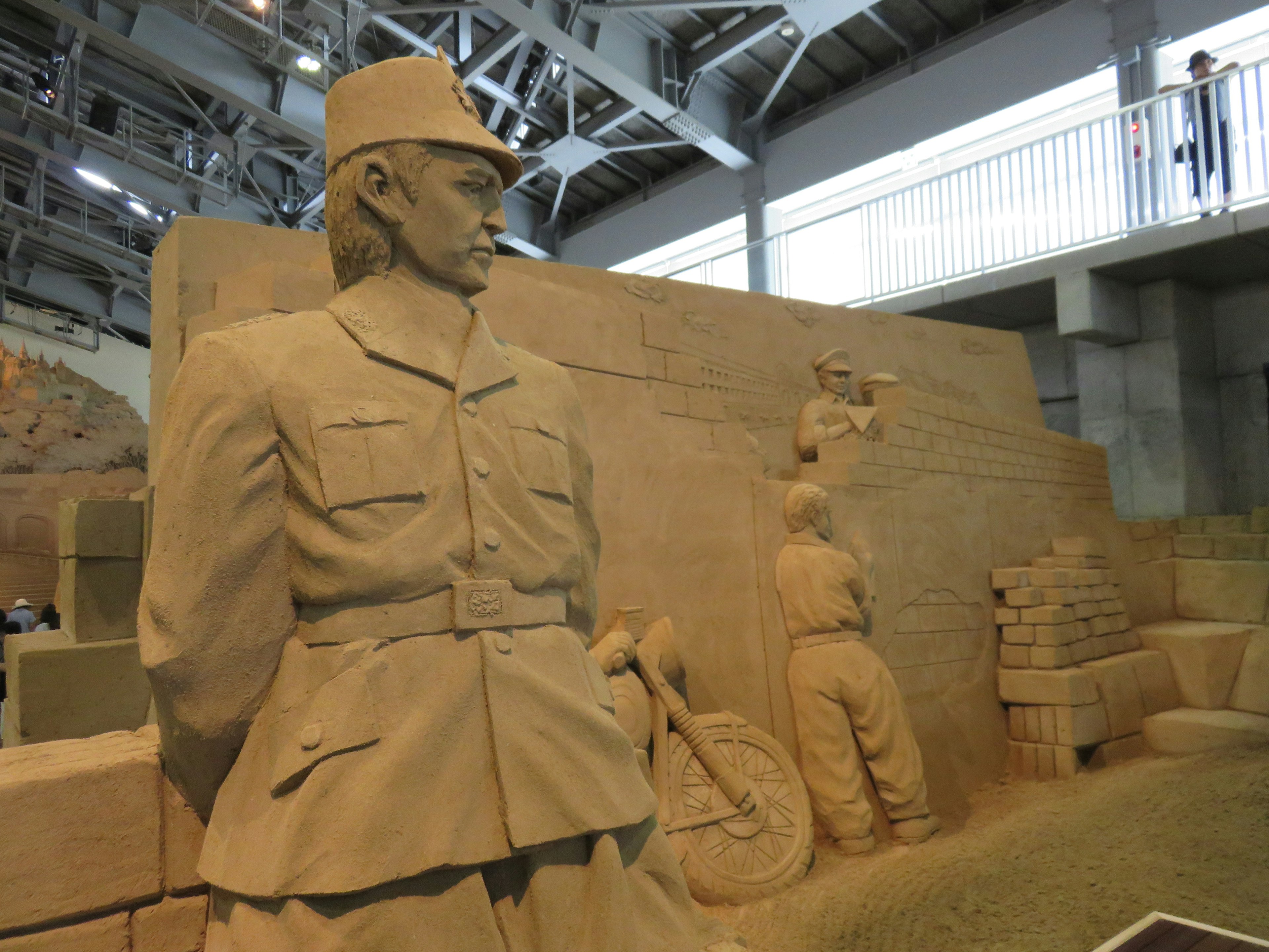 Sand sculpture of a soldier with additional figures in the background