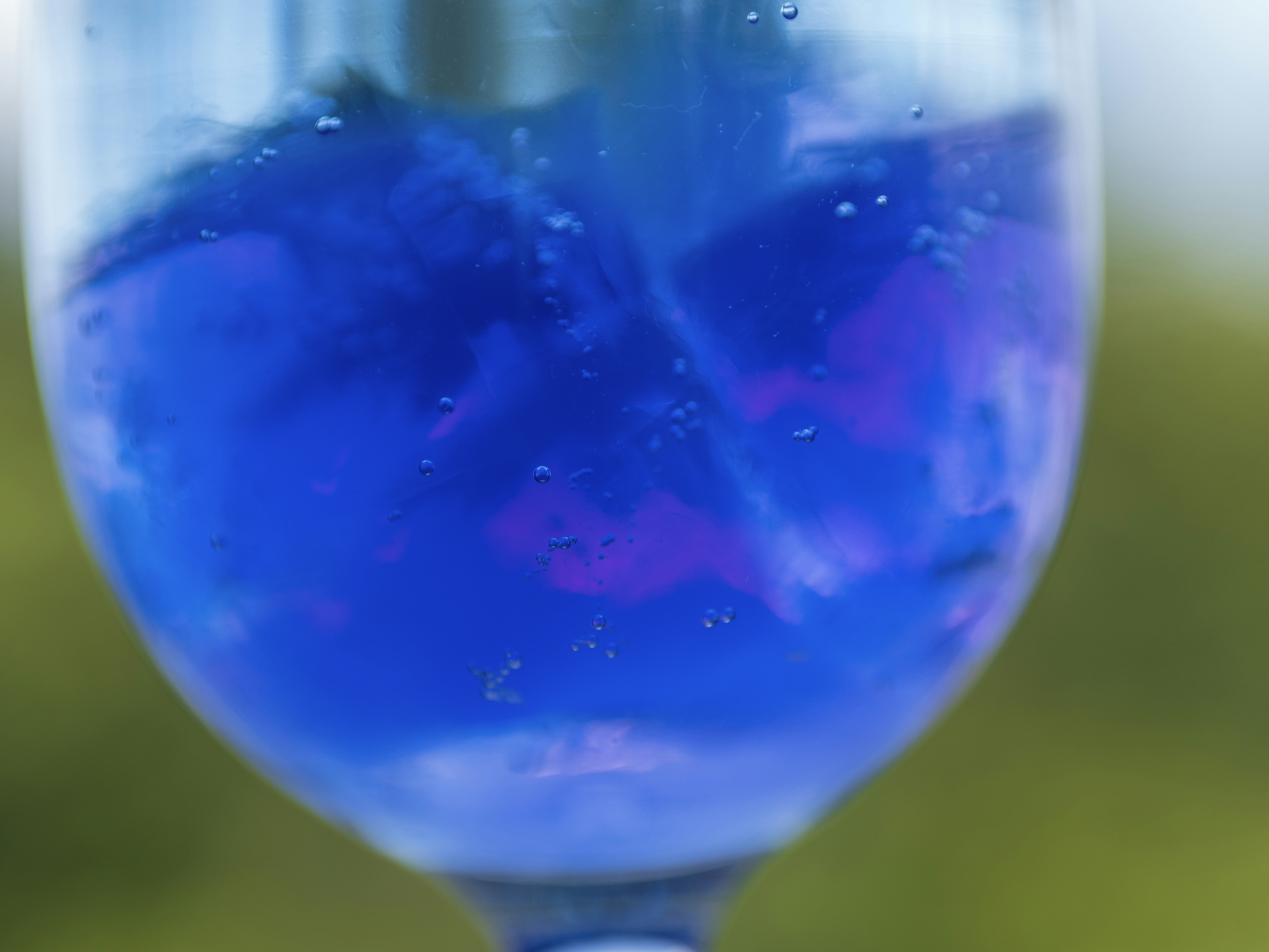 Gambar close-up gelas yang diisi minuman biru