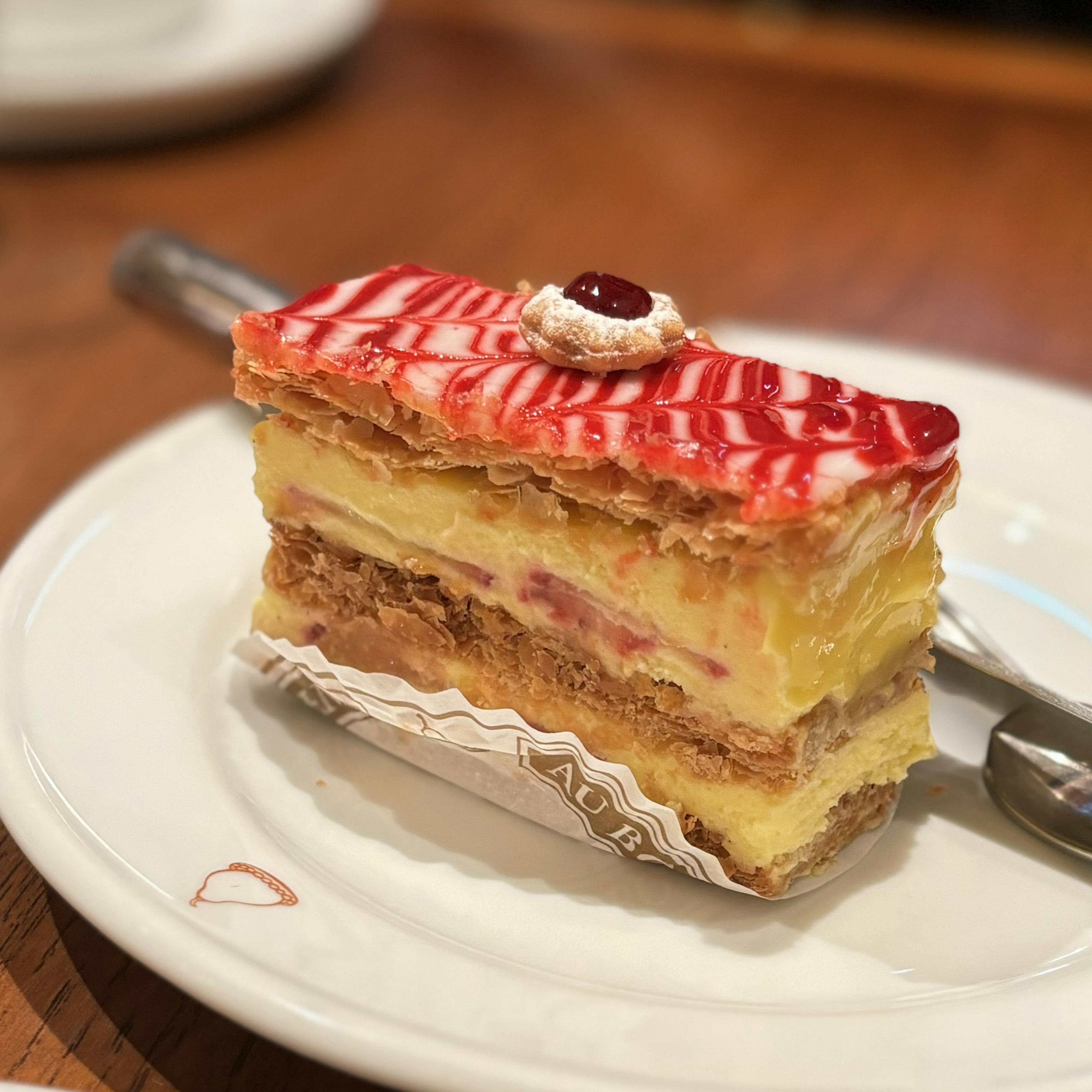 美しい層のケーキに赤いストライプのトッピングが施されている