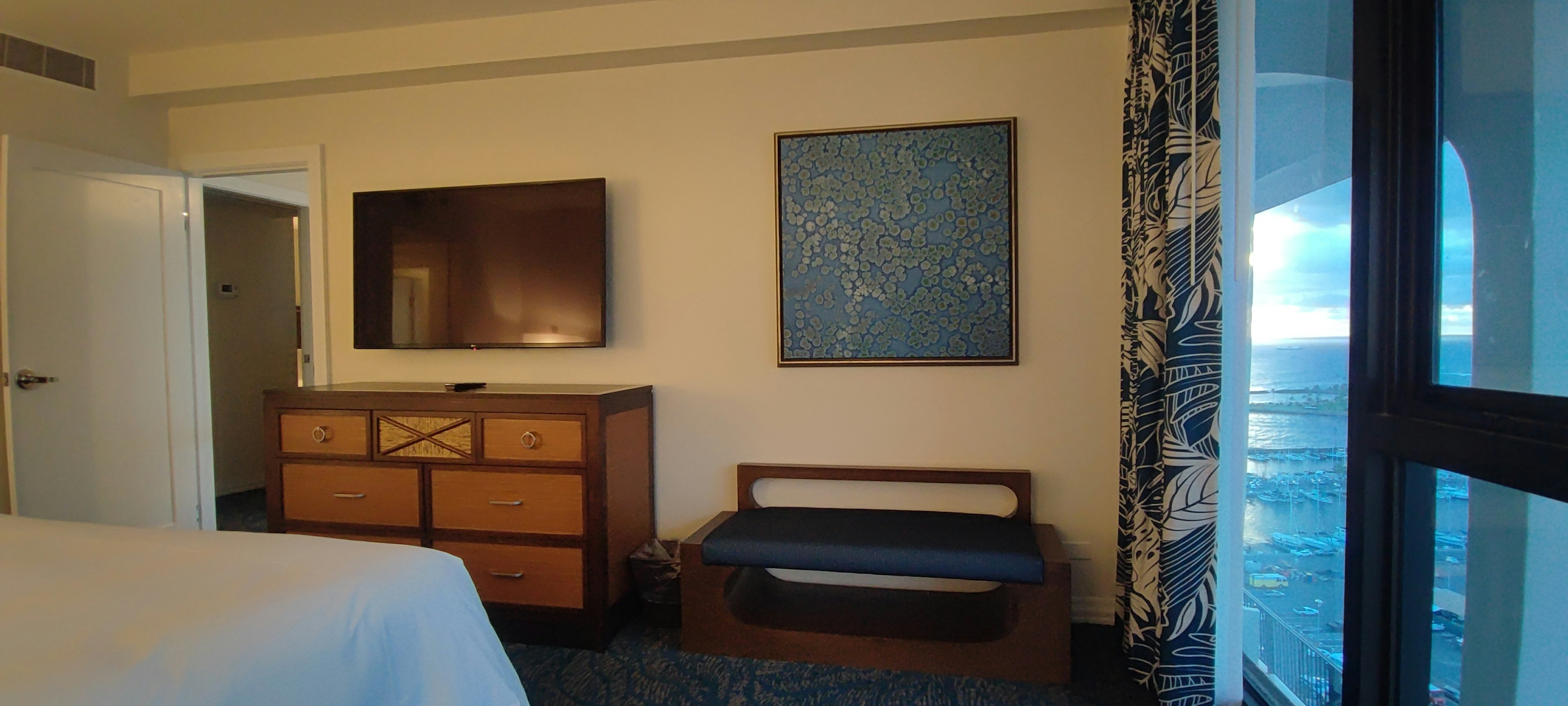 Modernes Hotelzimmer mit Fernseher Holzkommode und Wandkunst