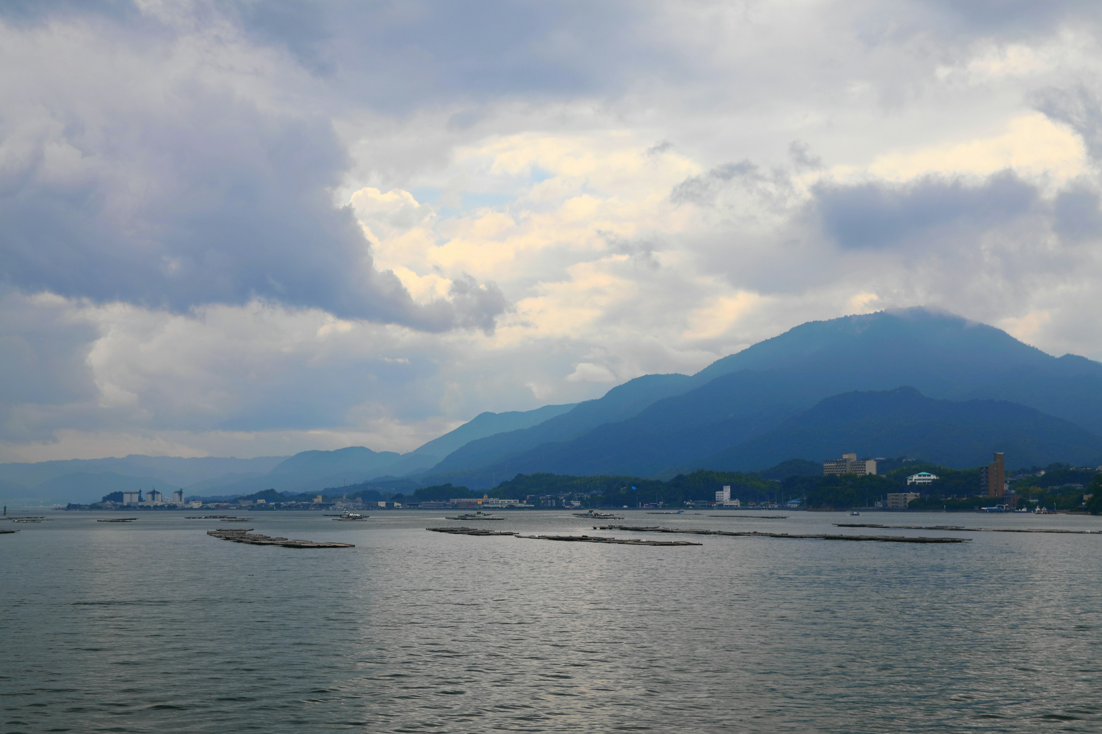 海洋与山脉的风景在多云的天空下