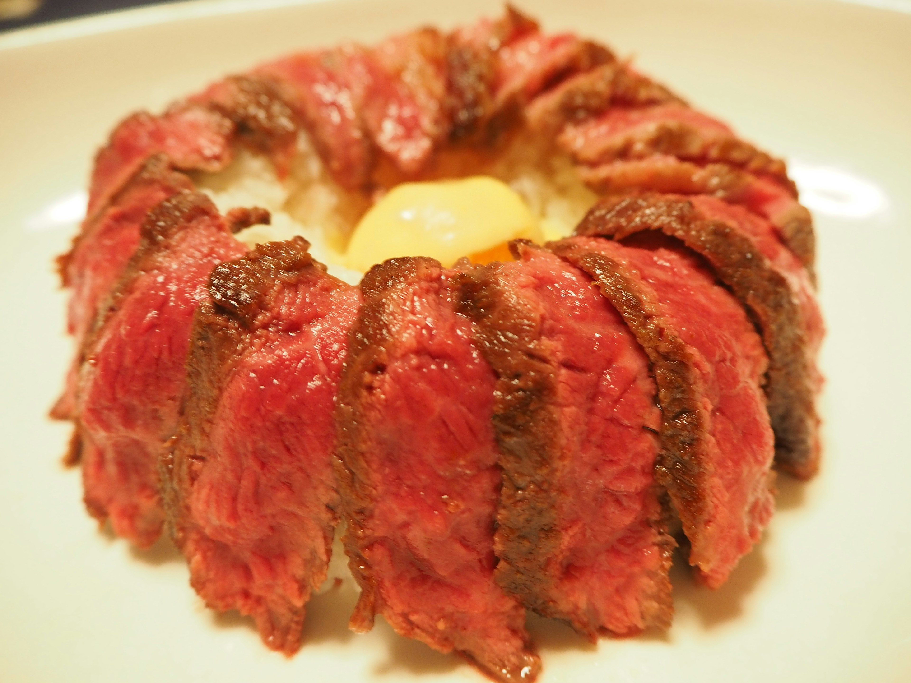 Plat avec une couronne de viande de bœuf entourant un jaune d'œuf