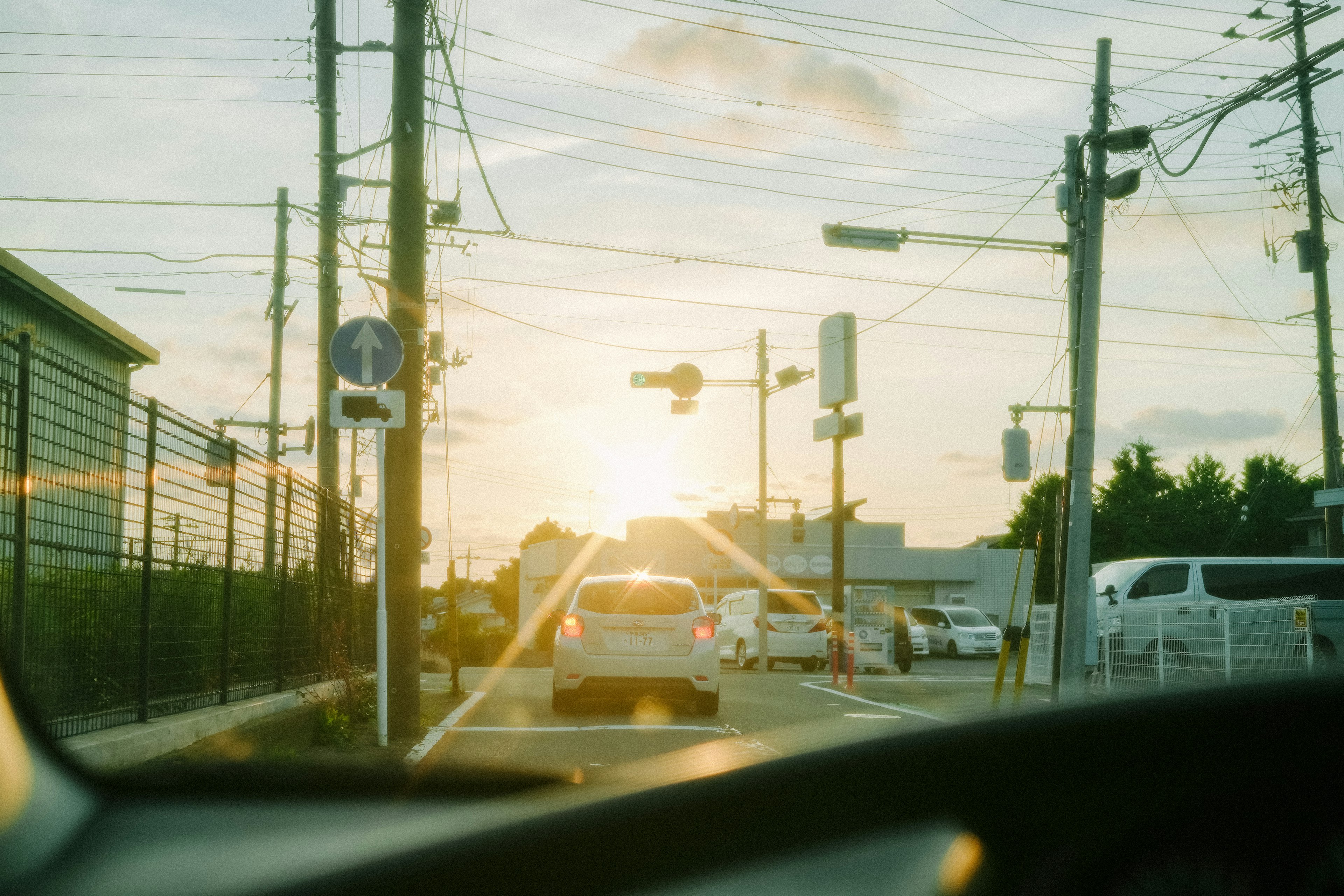 Escena de tráfico con atardecer de fondo y vehículos