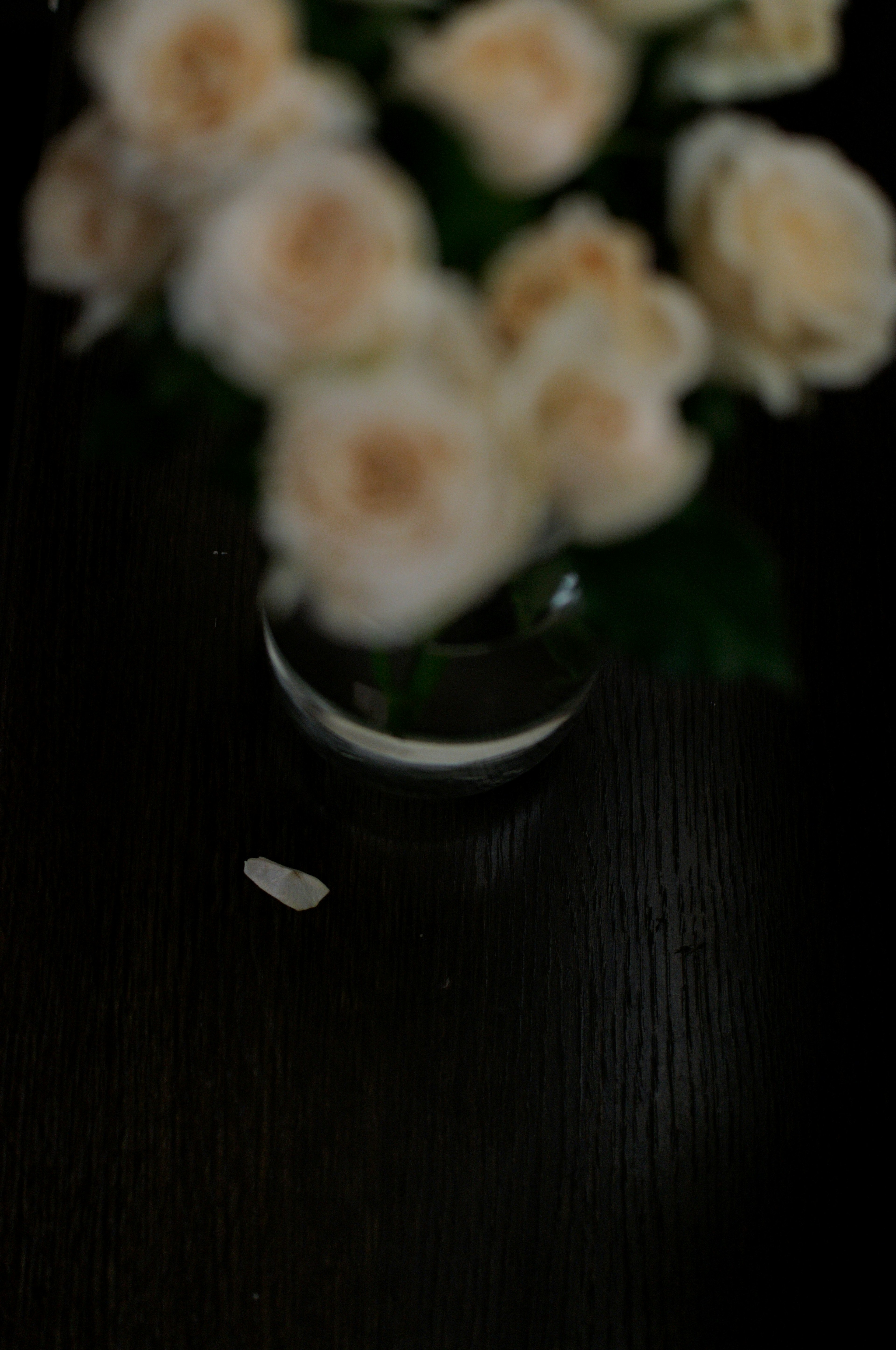 A bouquet of white roses in a clear vase