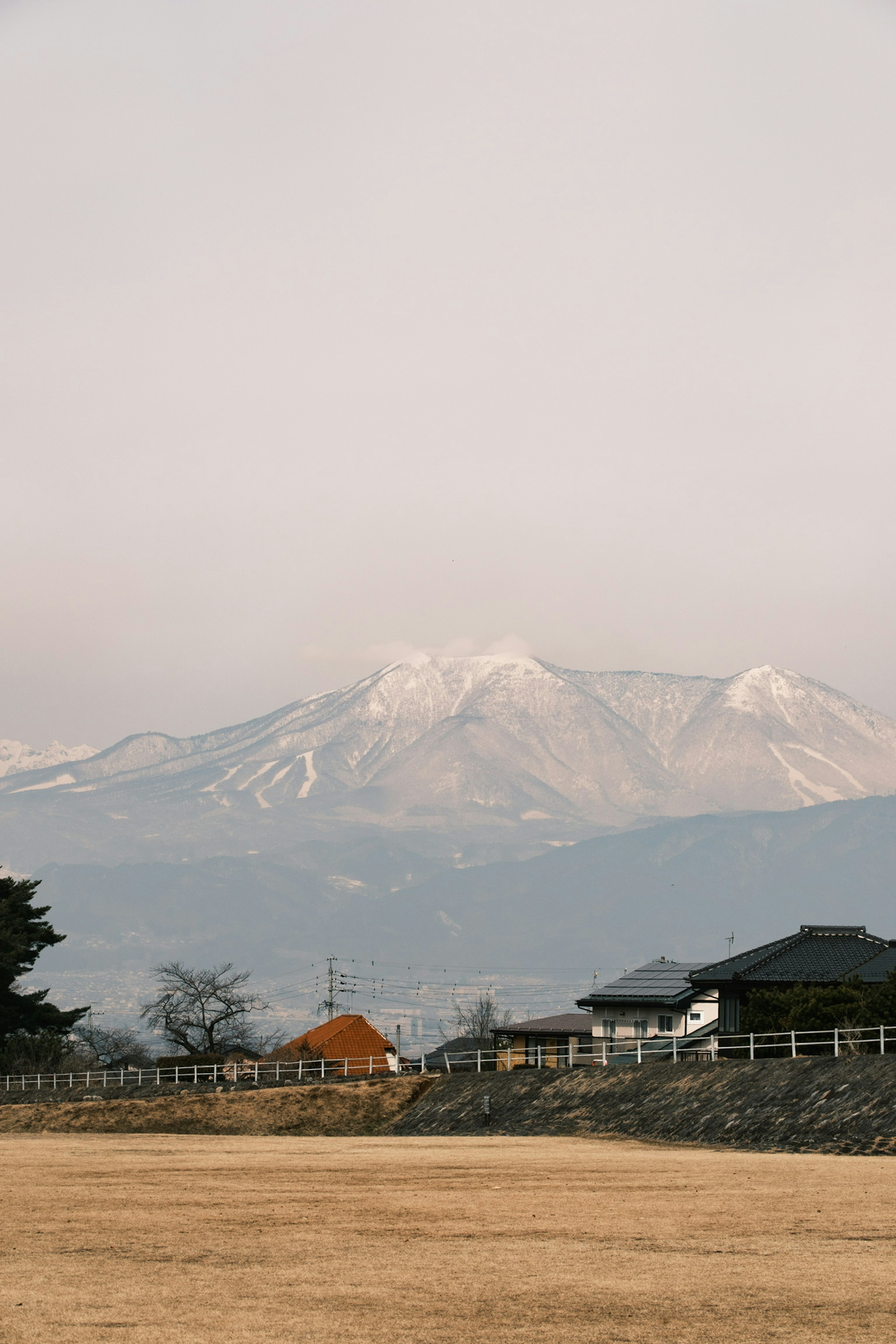 눈 덮인 산이 있는 농촌 풍경