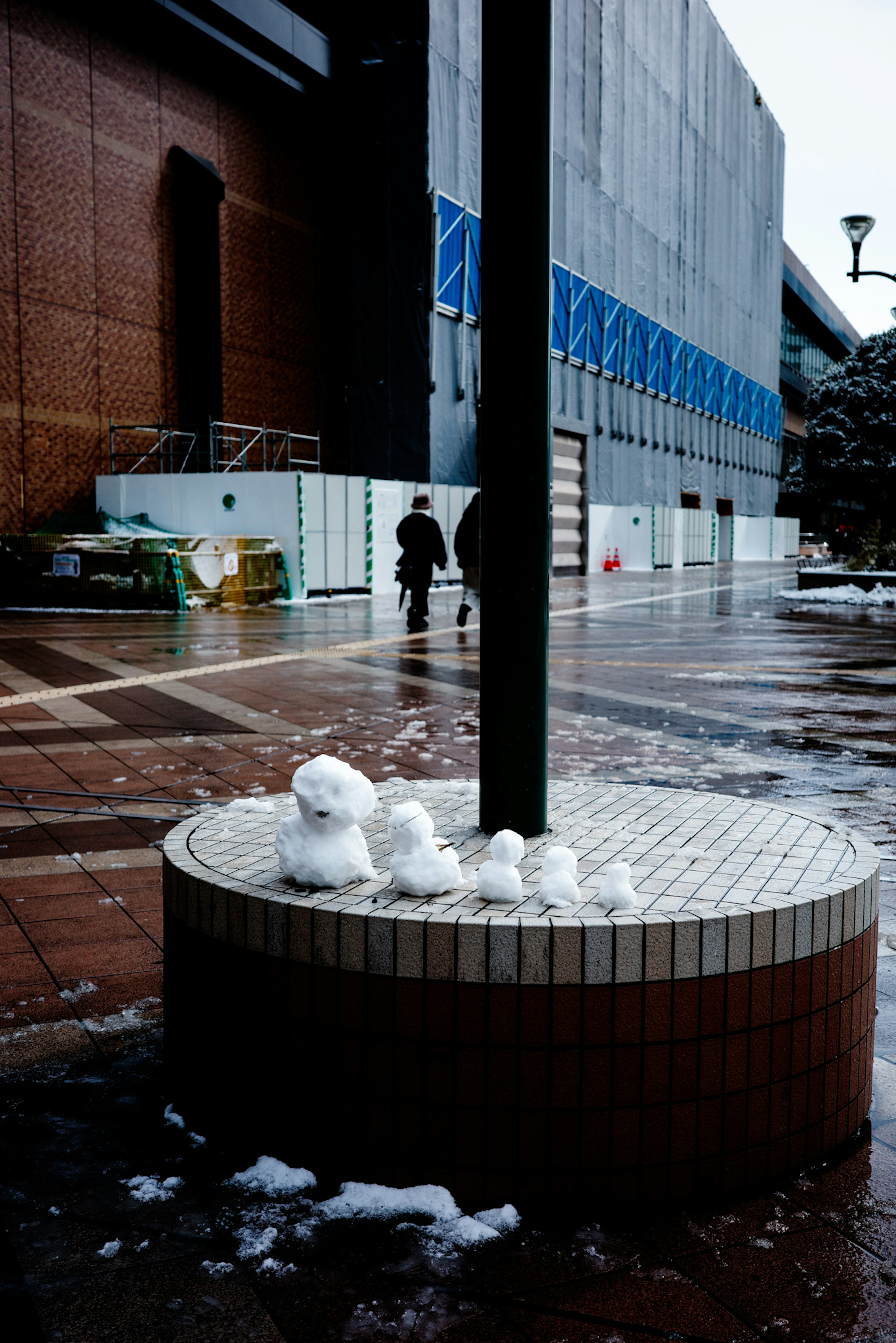 Formaciones de nieve en una plaza con un edificio al fondo