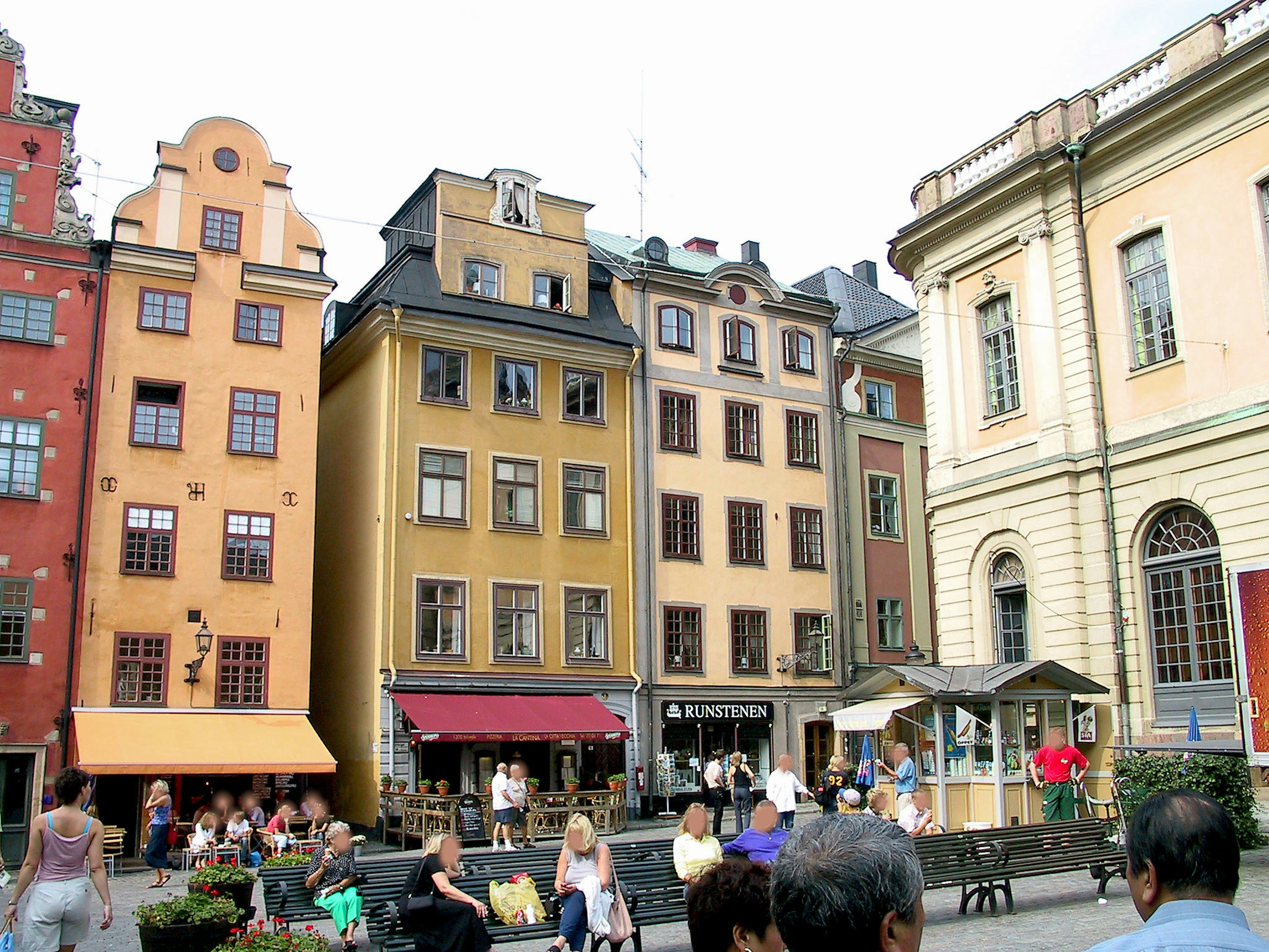 Alun-alun yang ramai di Stockholm dengan bangunan berwarna-warni dan kafe luar ruangan