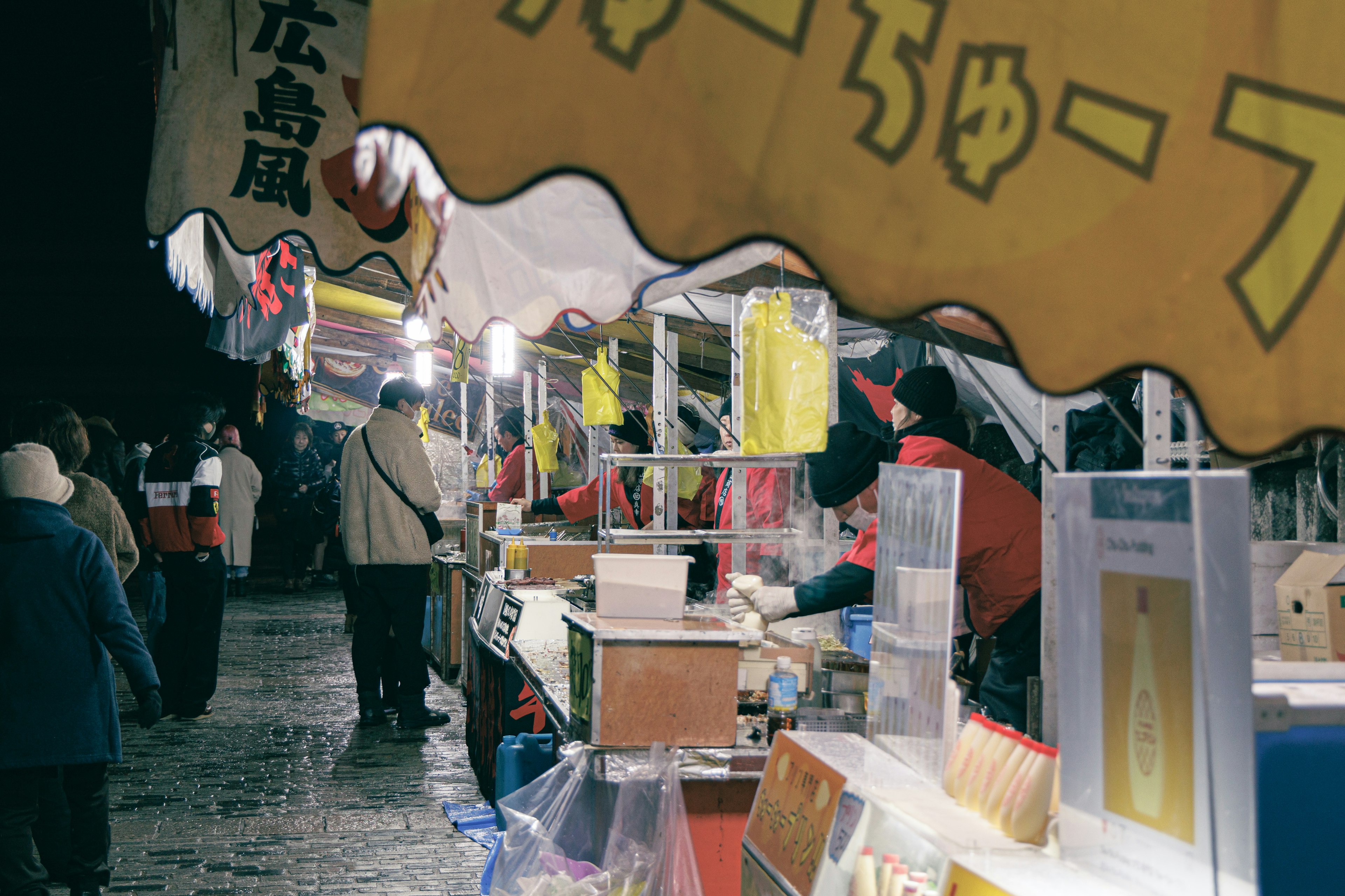 Scena di mercato notturno affollato con bancarelle di cibo