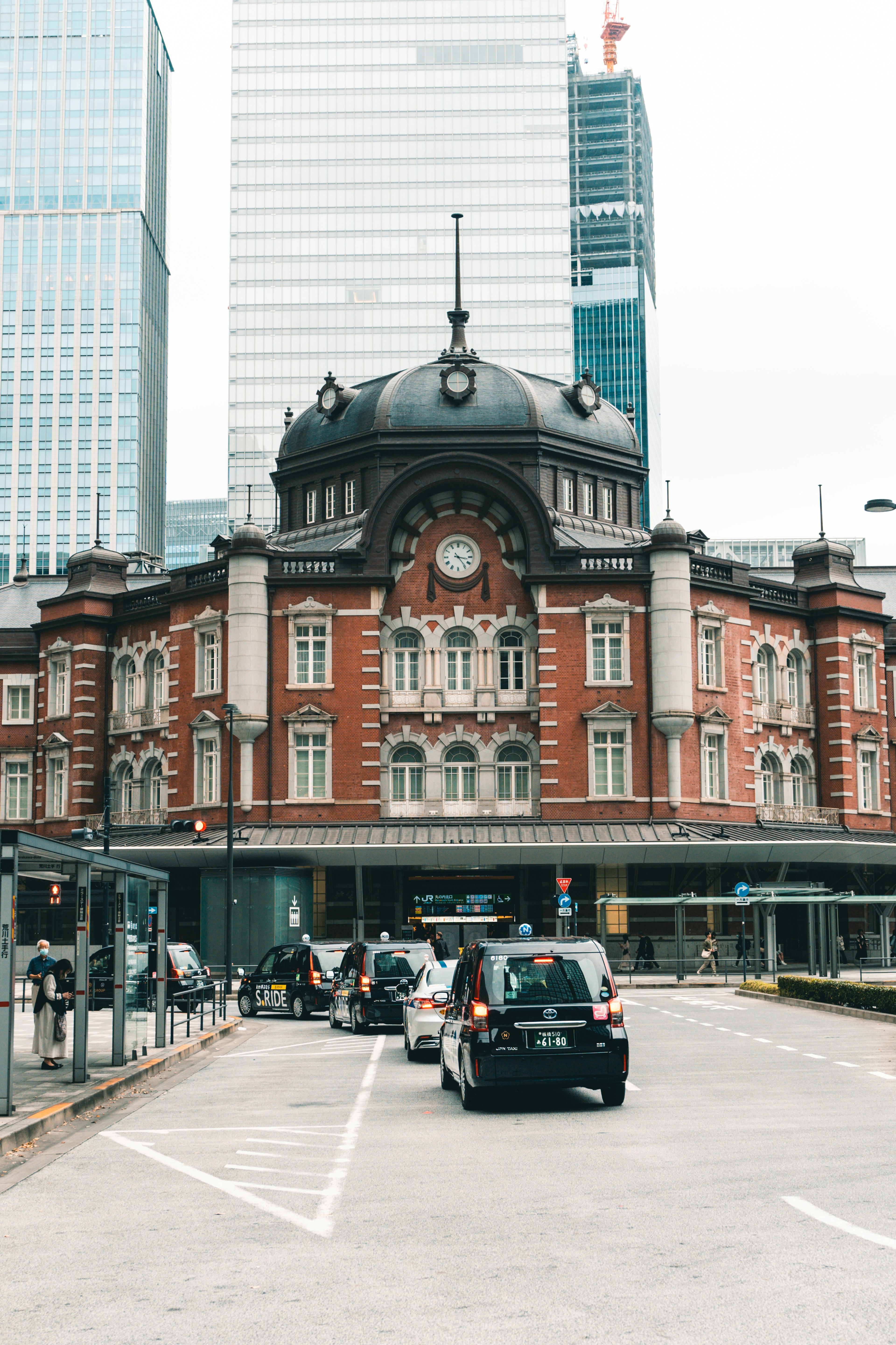 Historisches Gebäude des Bahnhofs Tokio mit modernen Wolkenkratzern im Hintergrund