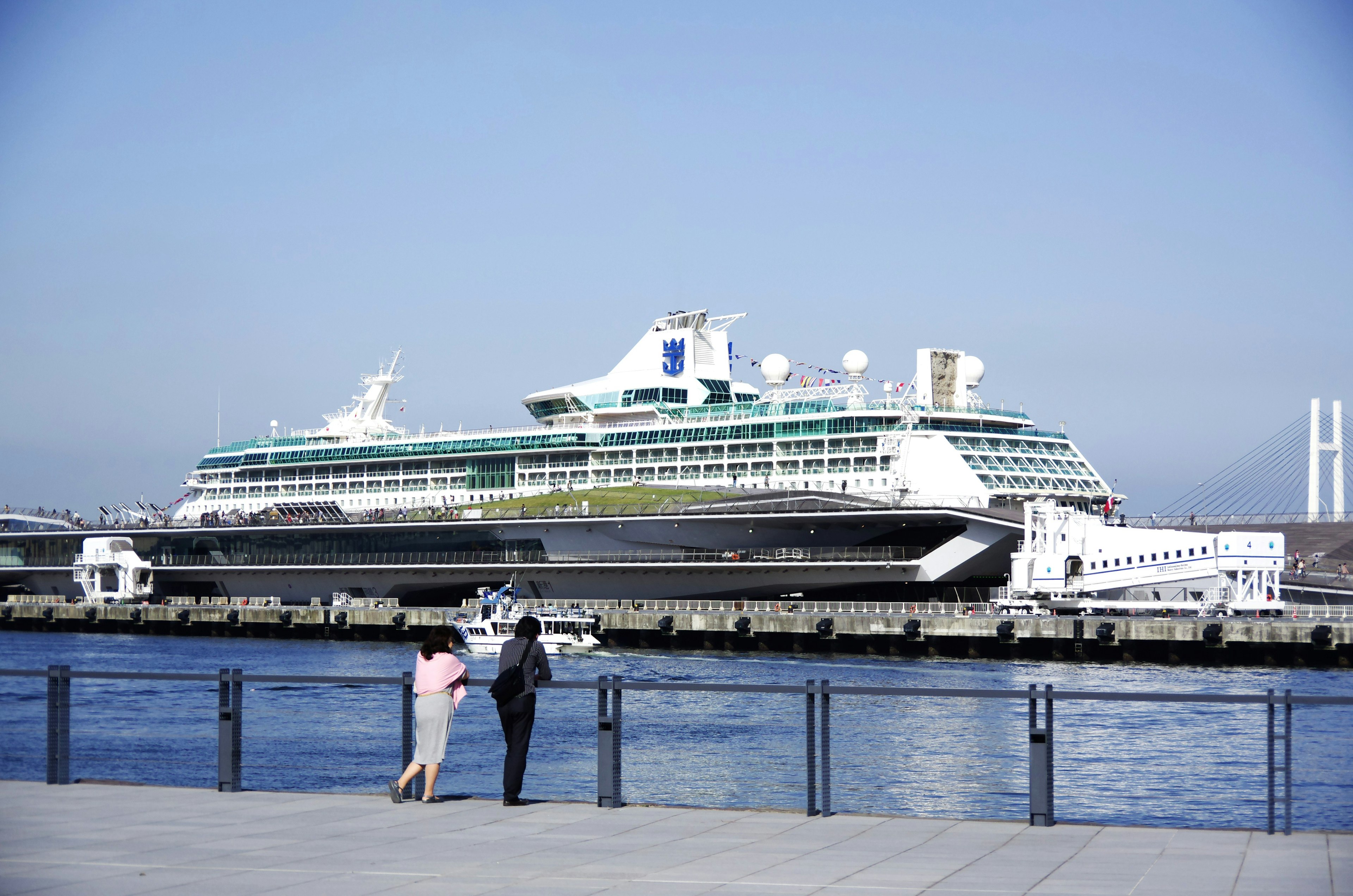 Paar, das ein Kreuzfahrtschiff am Wasser betrachtet