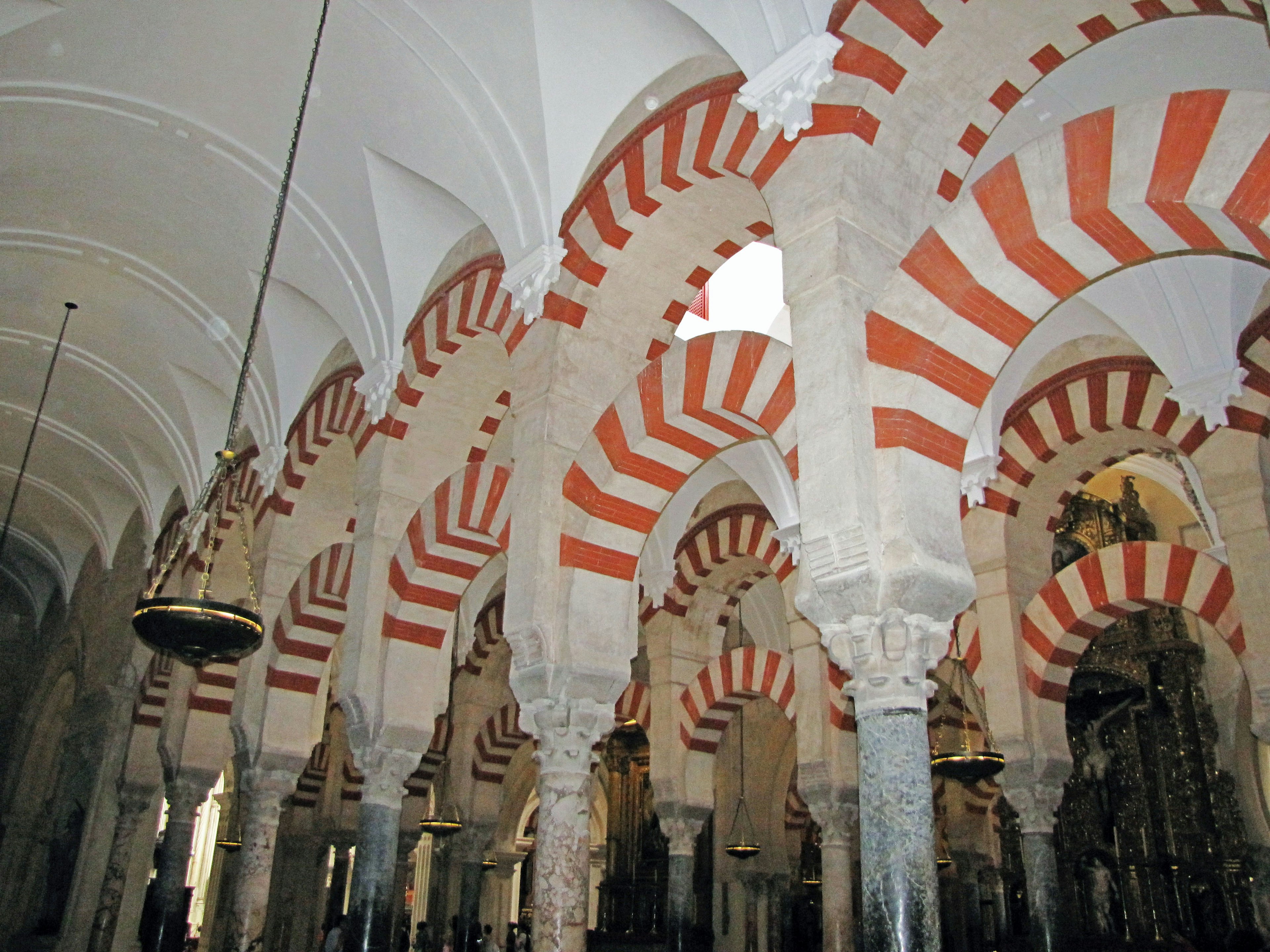 Intérieur de la mosquée-cathédrale de Cordoue avec des arches rayées rouges et blanches