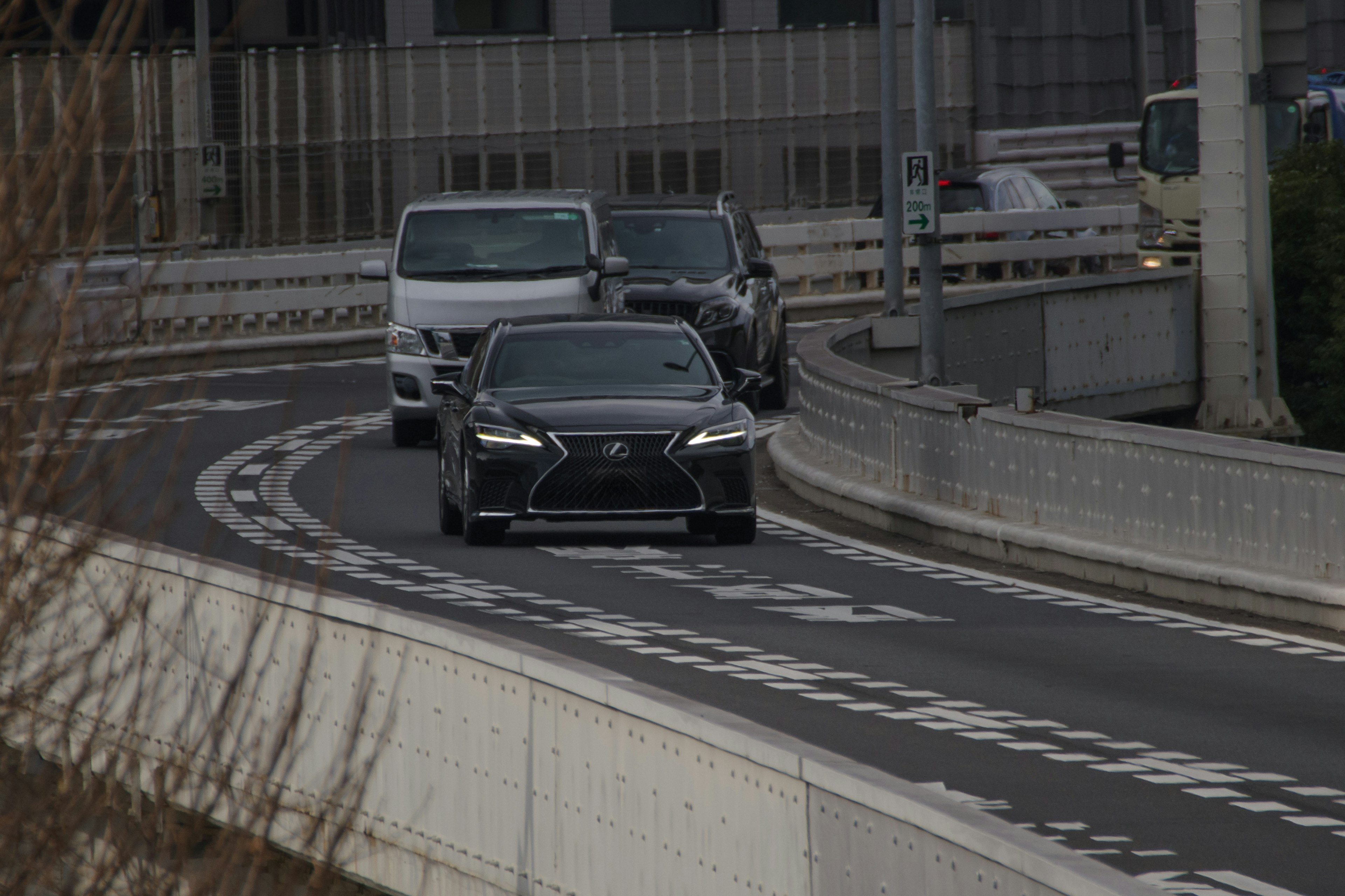 Schwarzes Luxusauto, das eine Kurve auf einer Stadtstraße nimmt