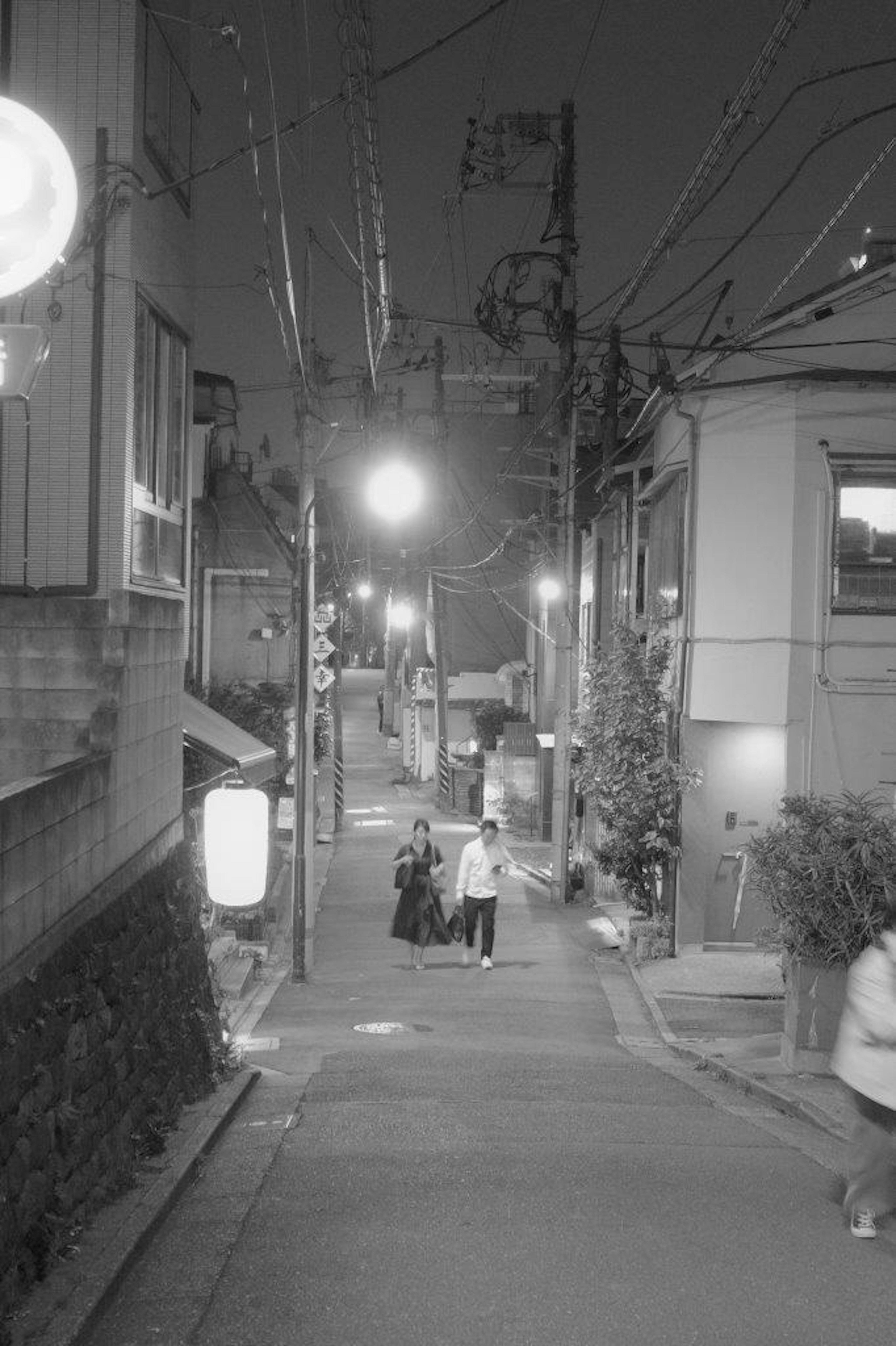 Un callejón tranquilo por la noche con una persona caminando