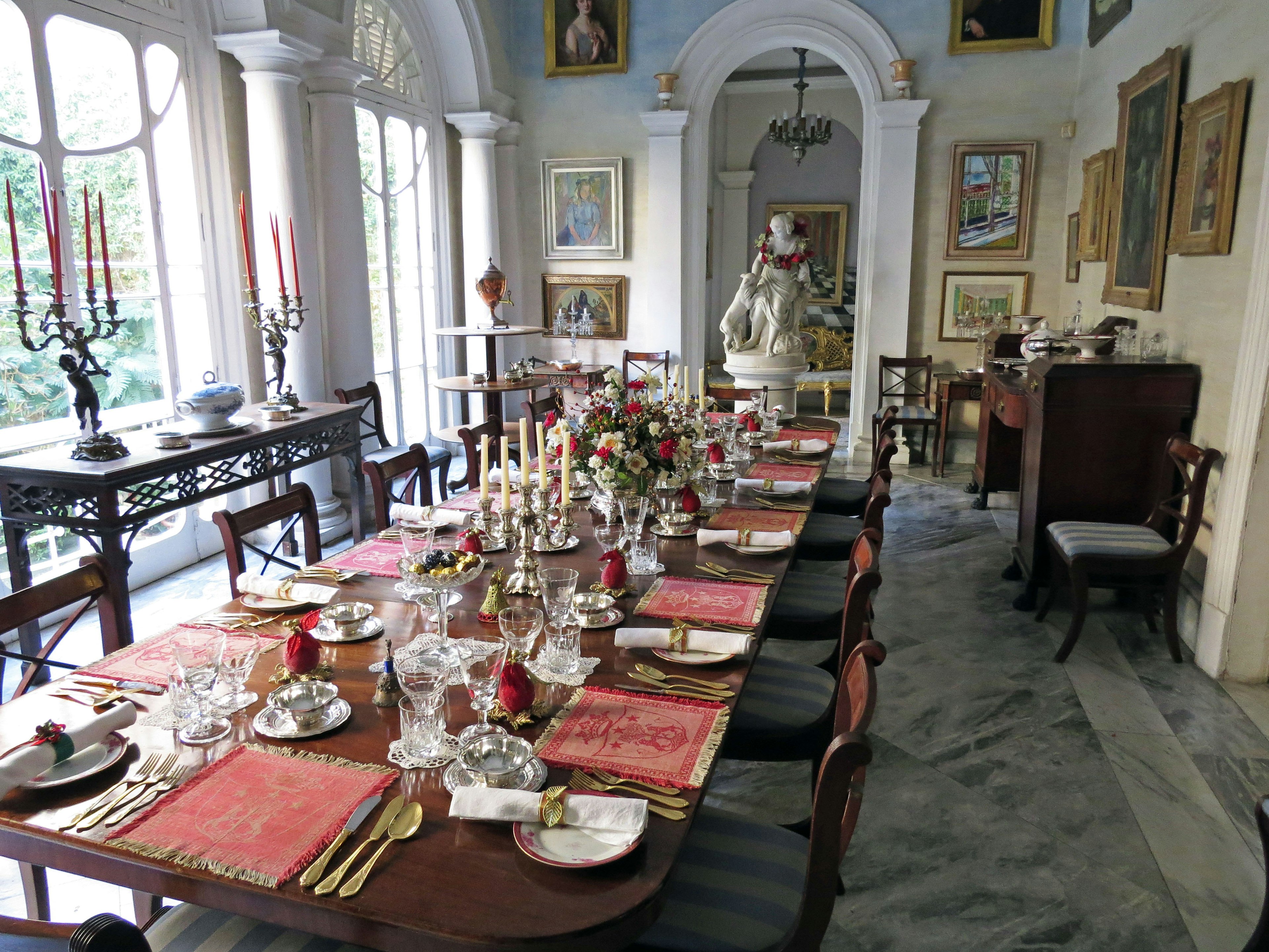 Elegante sala da pranzo con un tavolo splendidamente apparecchiato con candele e porcellana fine