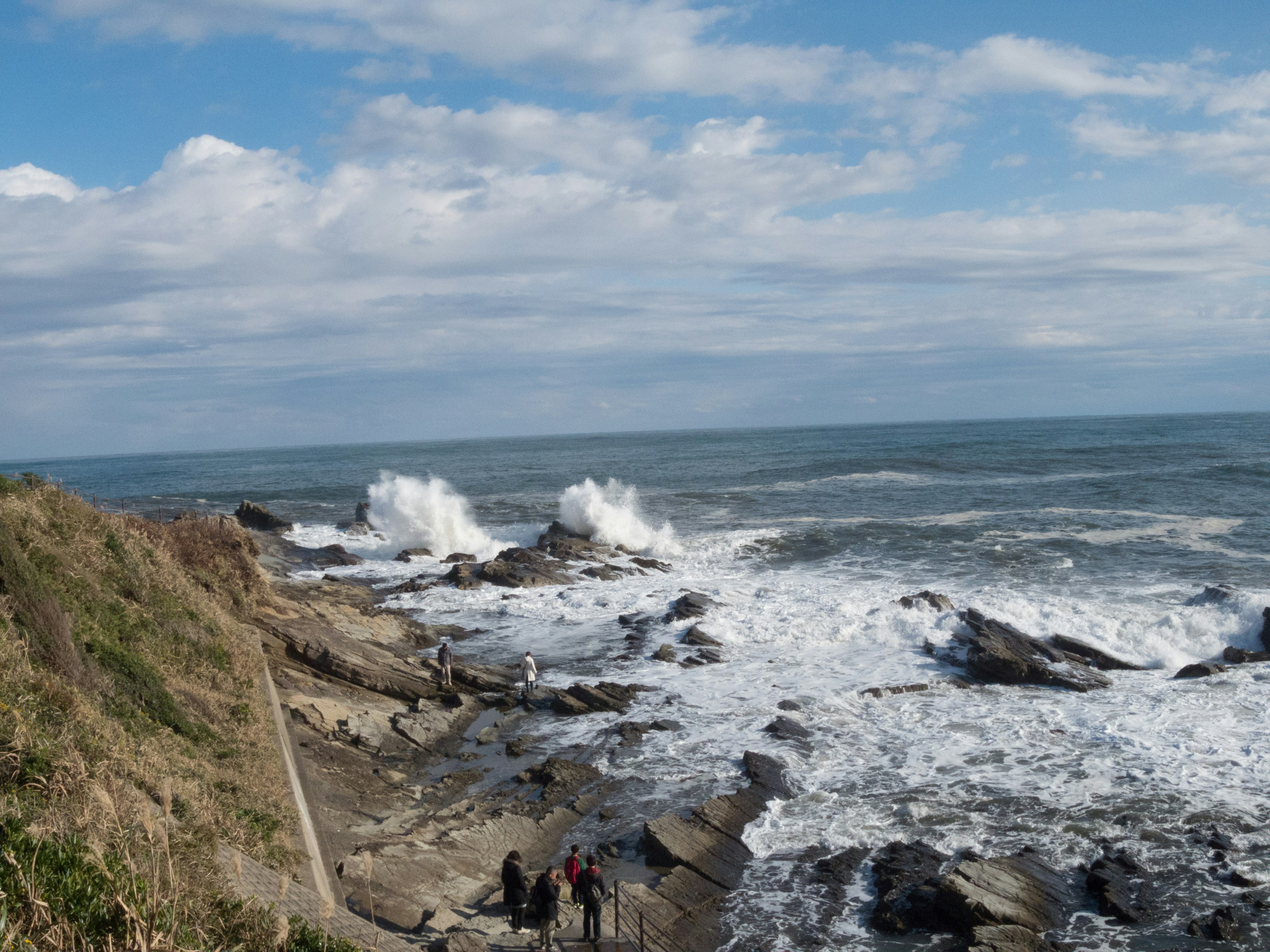 Coastal scene with crashing waves and a blue sky