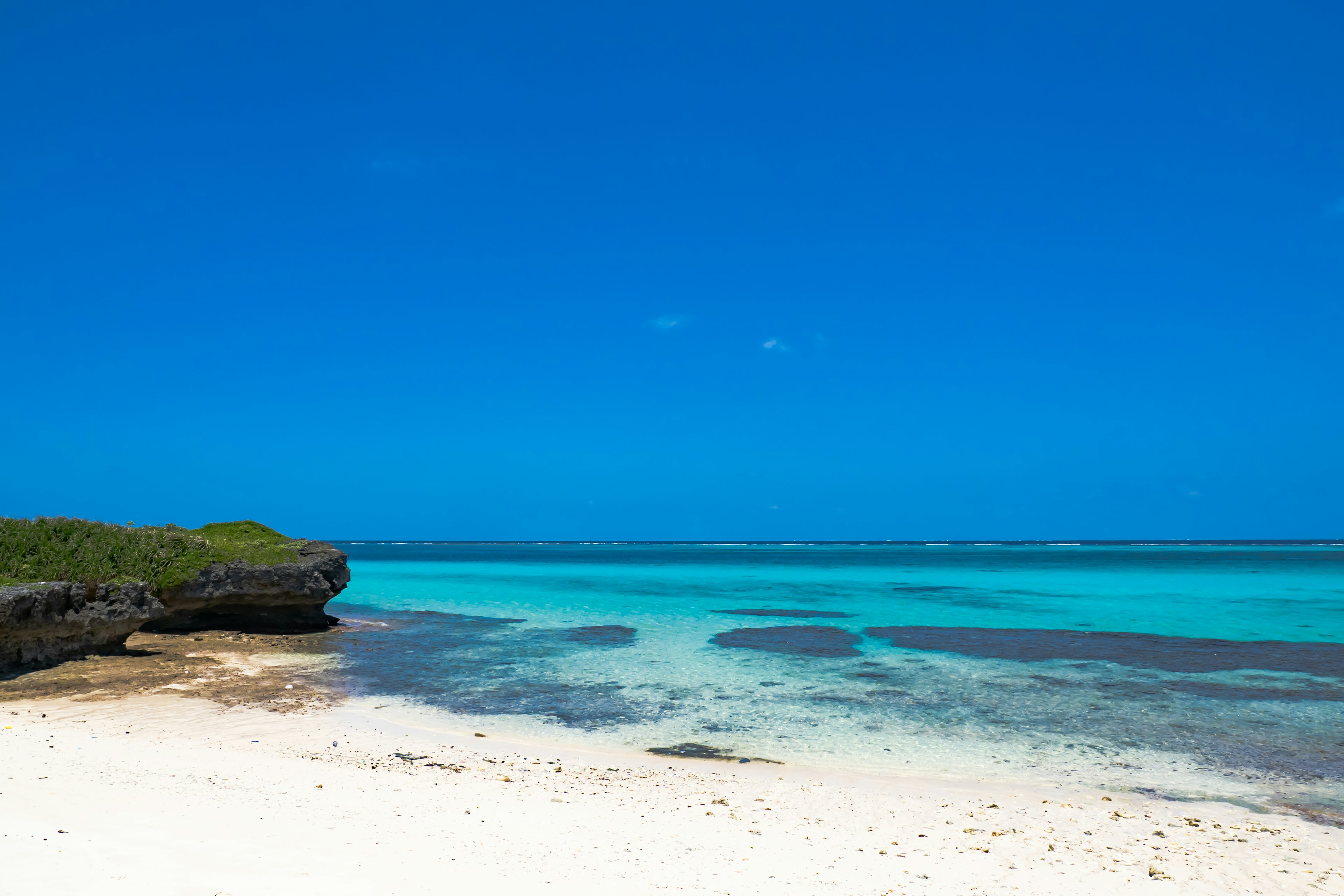 Una escena de playa con cielo azul y aguas turquesas