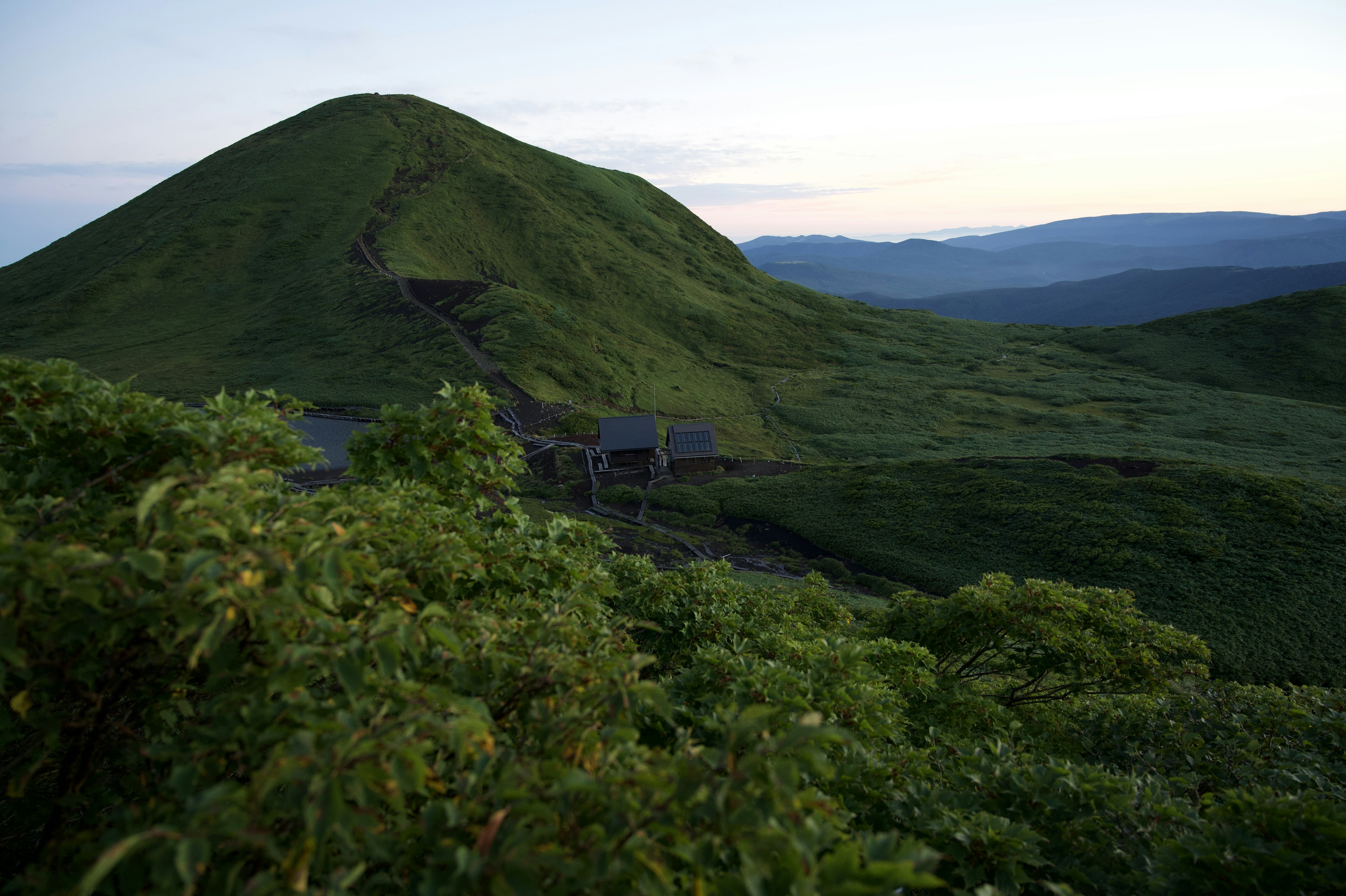 青々とした山と丘の風景、静かな夕暮れの空