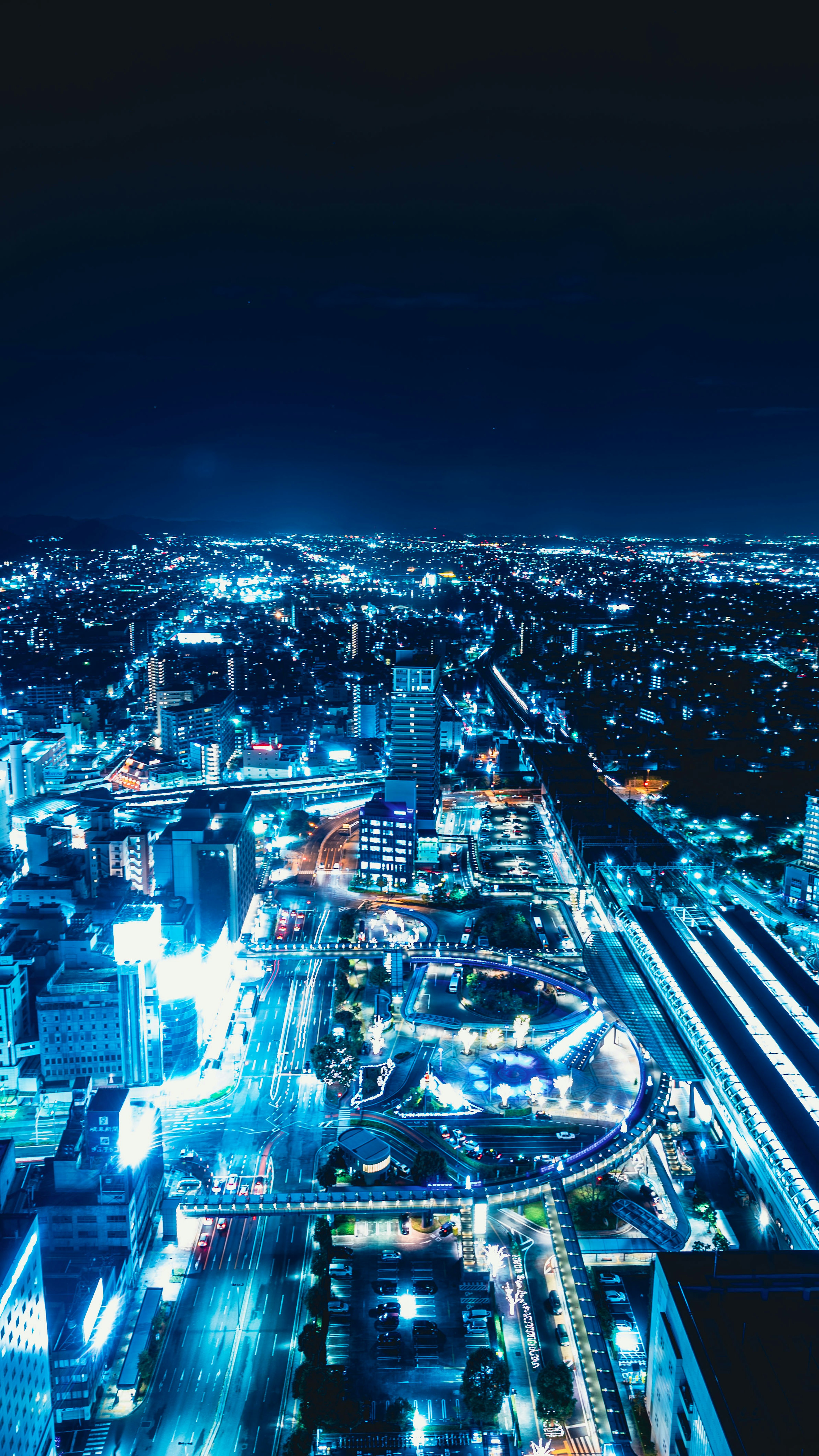 Paisaje urbano nocturno con edificios iluminados y calles