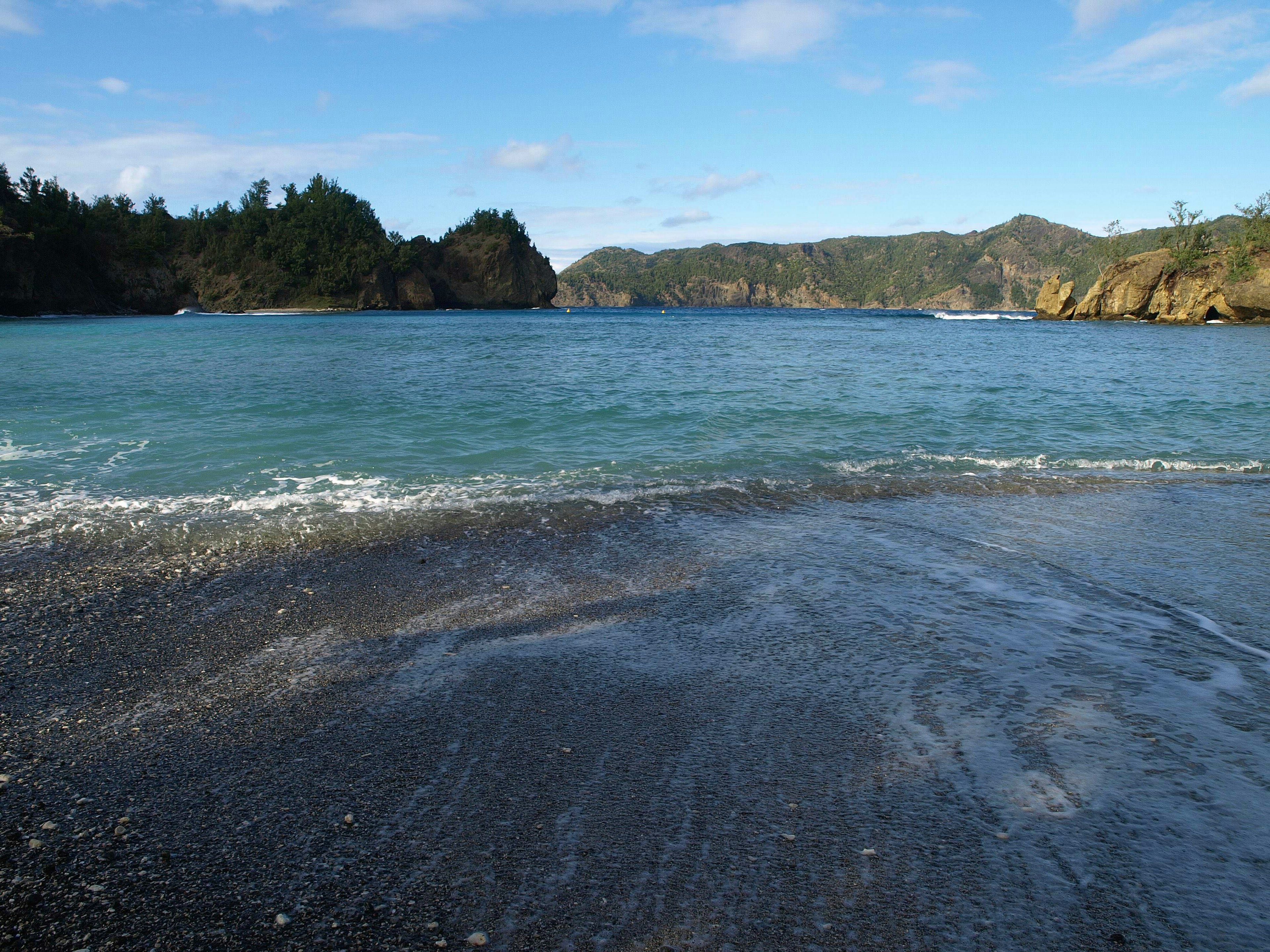 Scenic view of blue ocean and black sandy beach