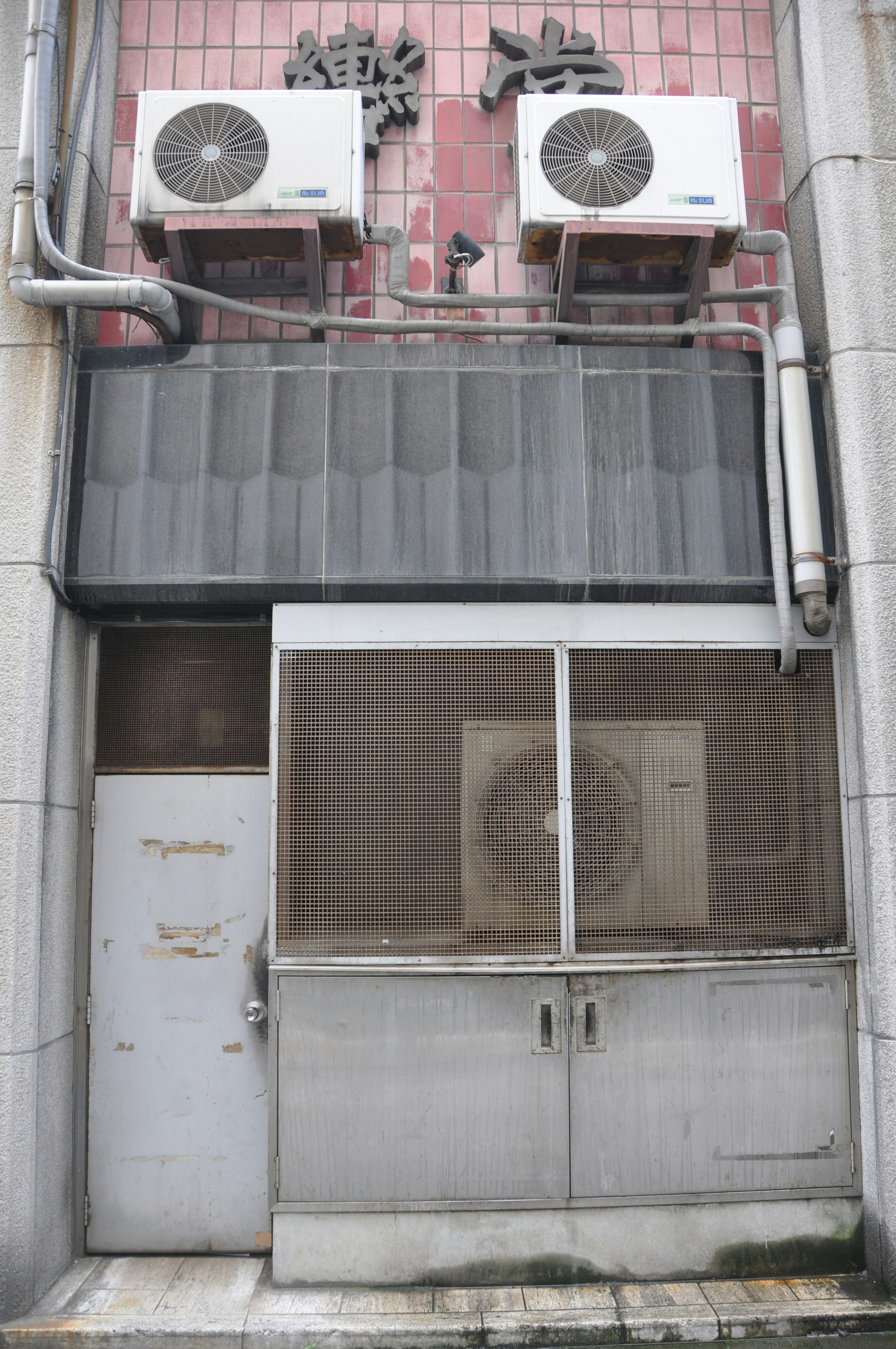 Puerta de un edificio con unidades de aire acondicionado en la pared