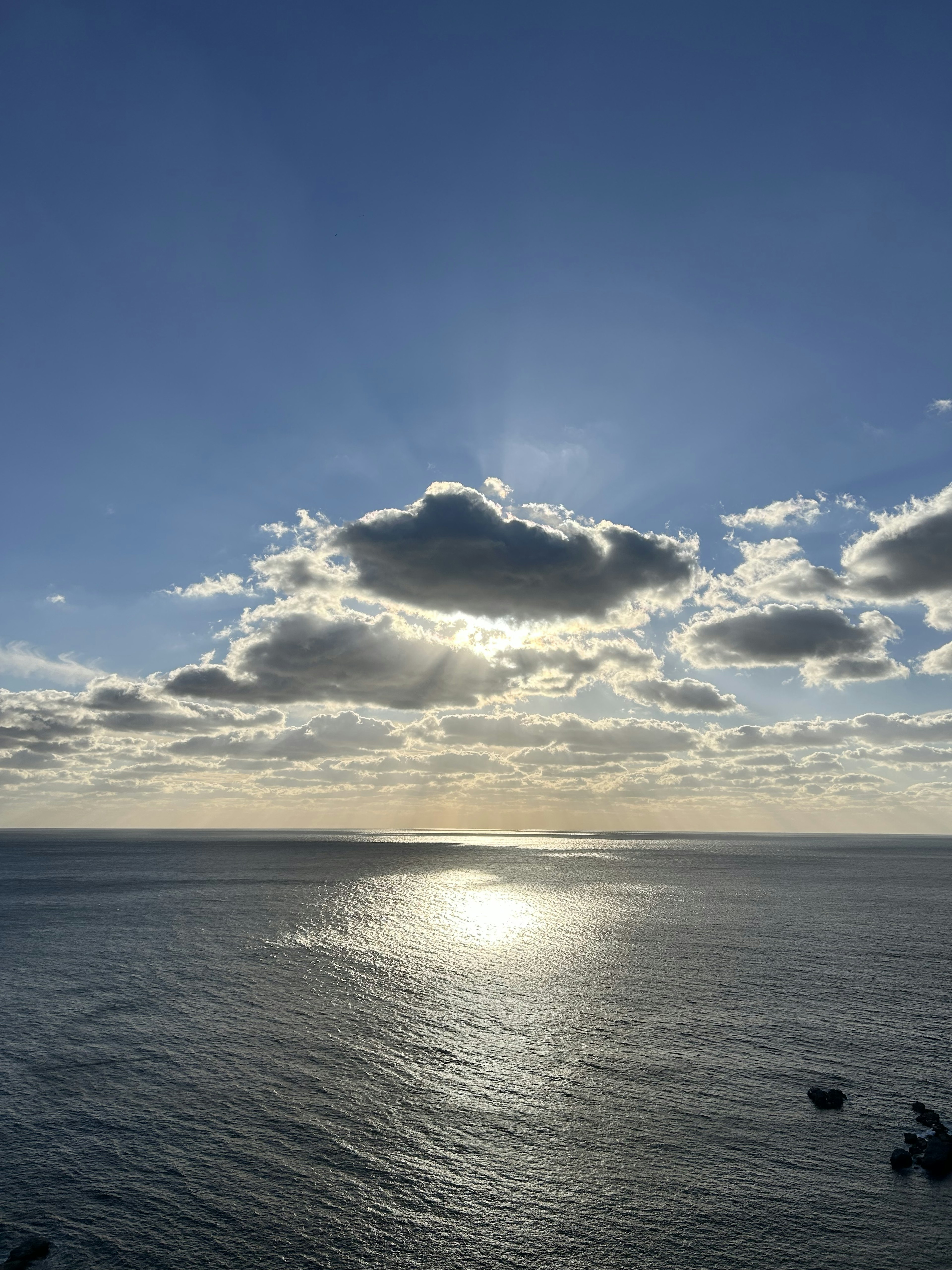 海と空の美しい風景 太陽が雲の間から輝いている