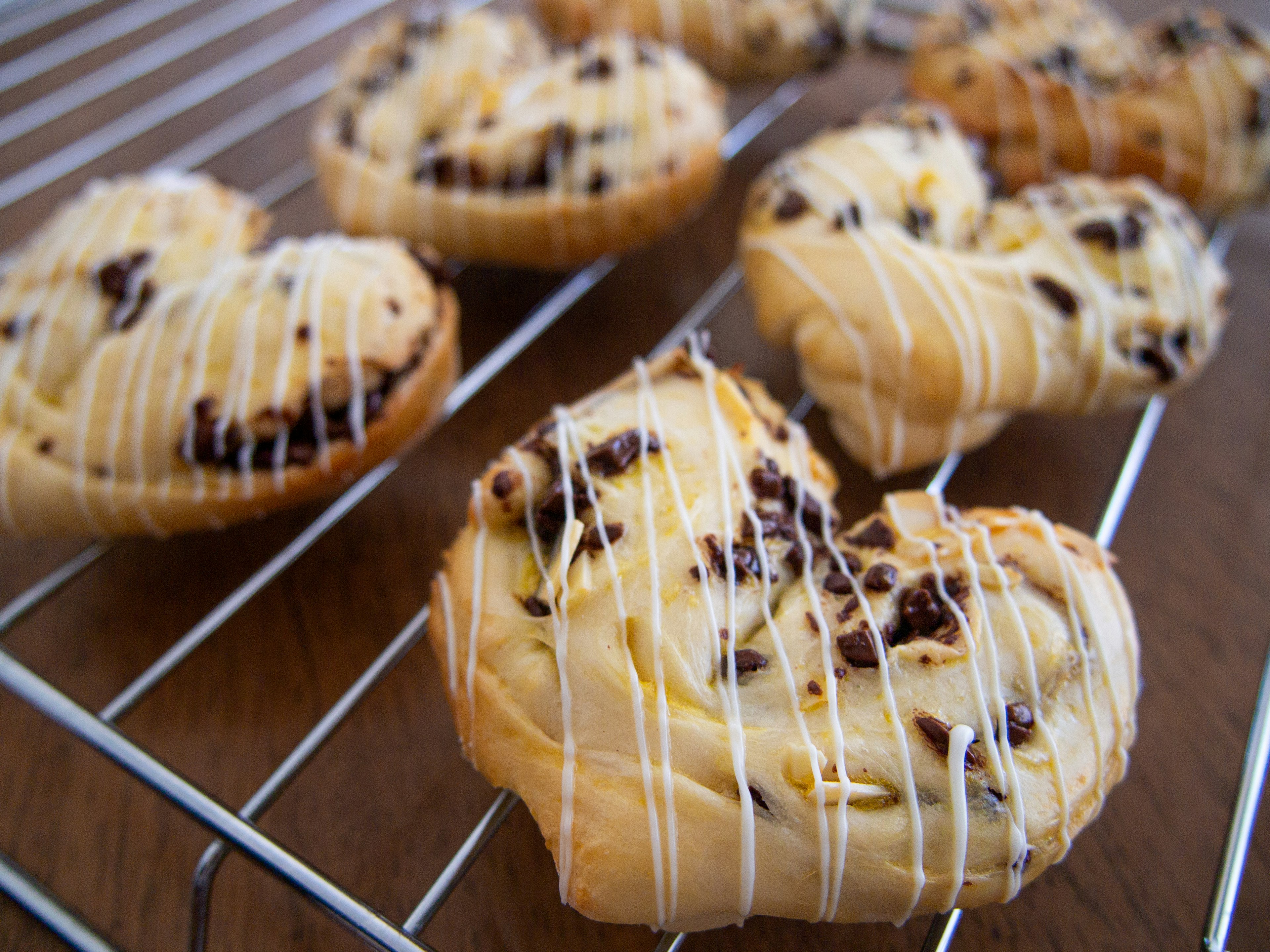 Heart-shaped pastries with chocolate chips and white chocolate drizzle