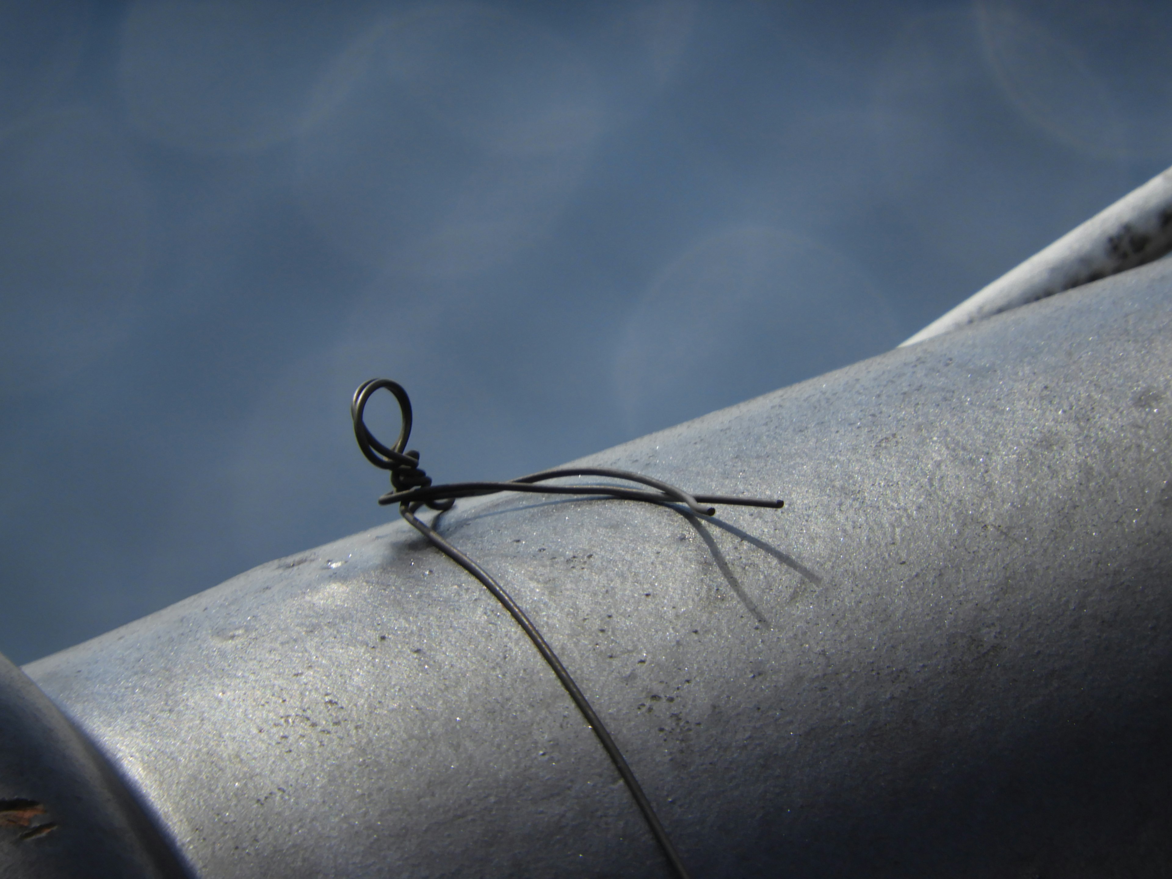 Black thread and loop on a metal pipe