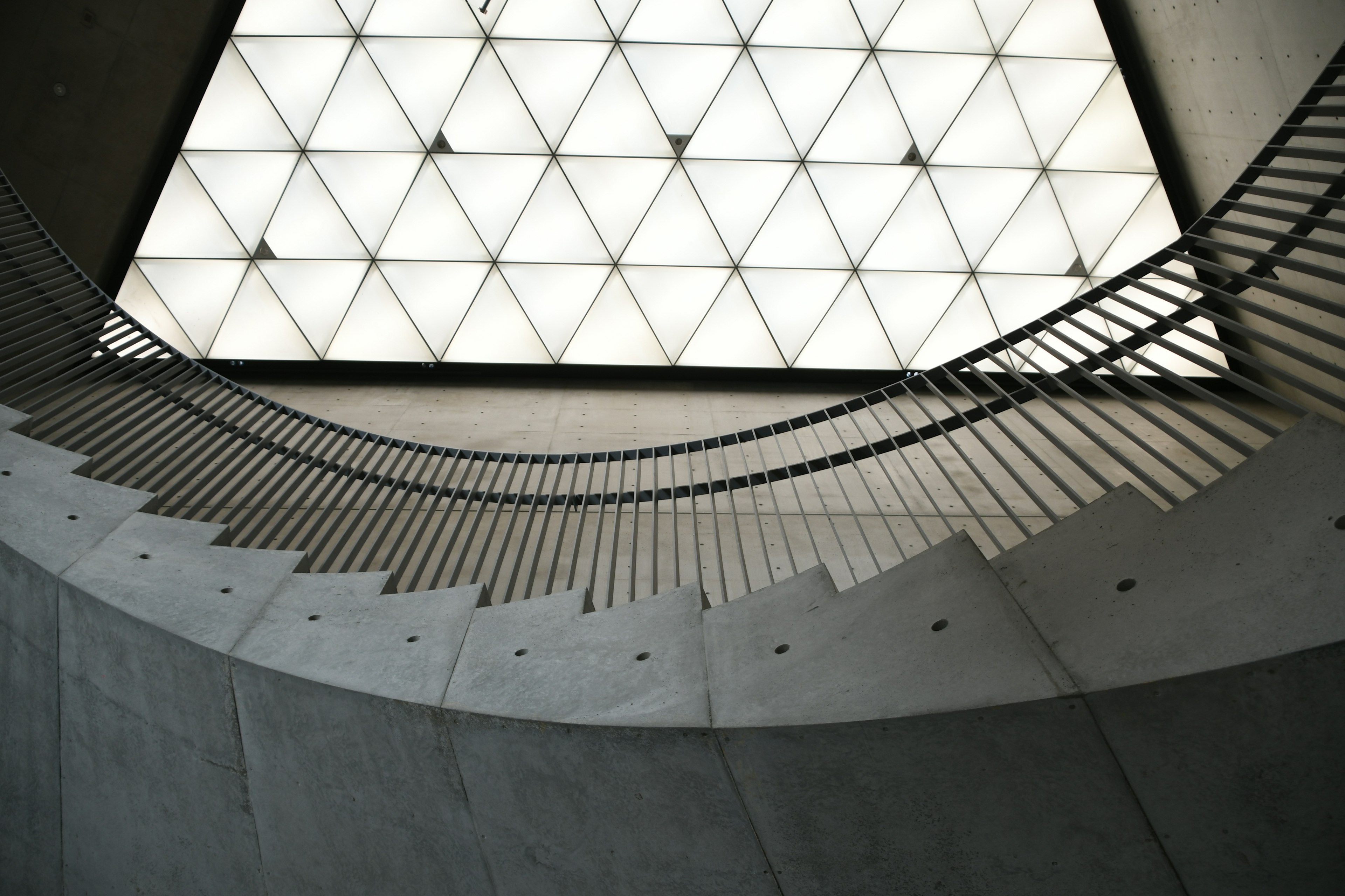 Modern architecture featuring curved staircase and triangular ceiling