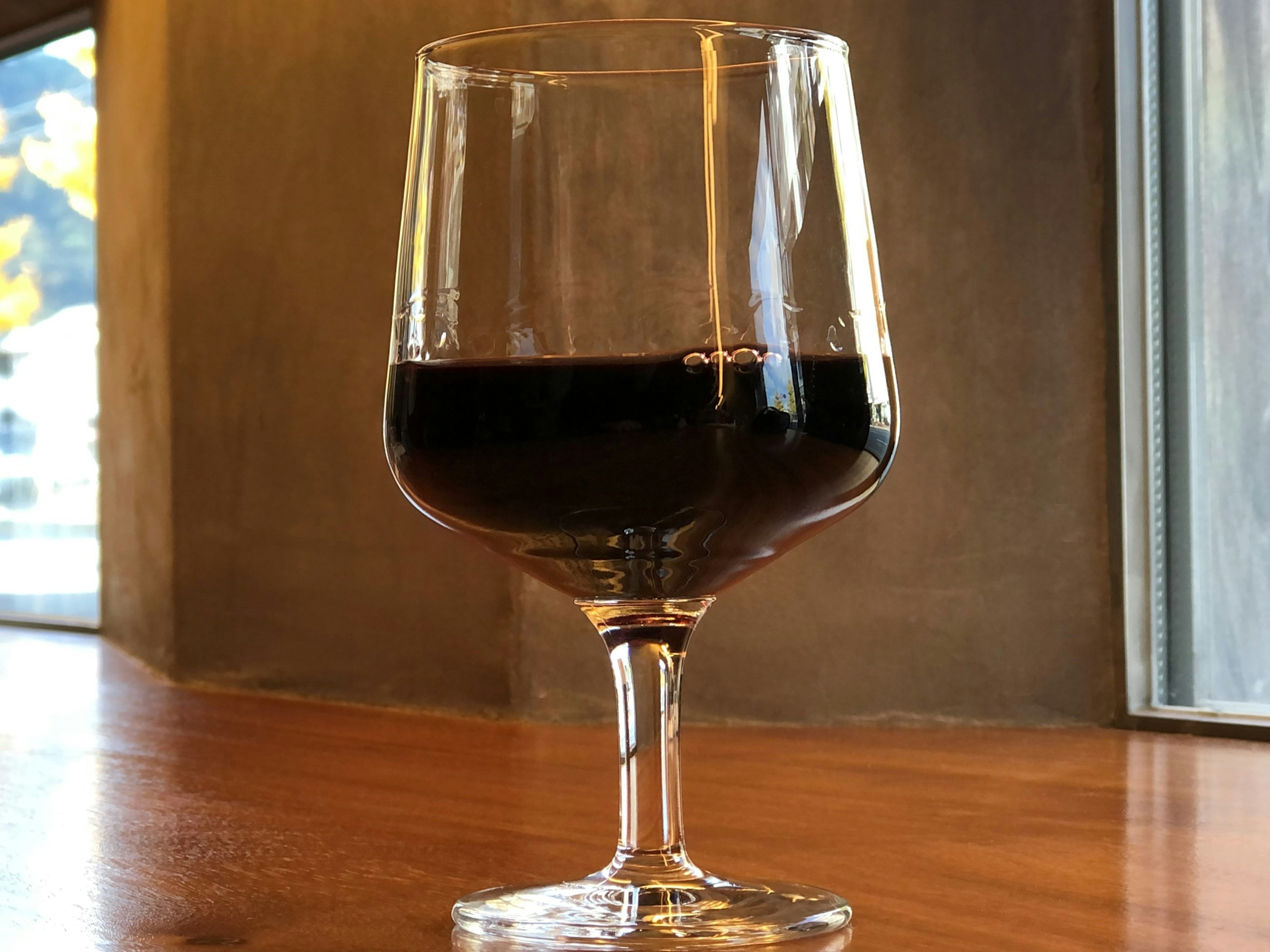 A glass of red wine on a wooden table