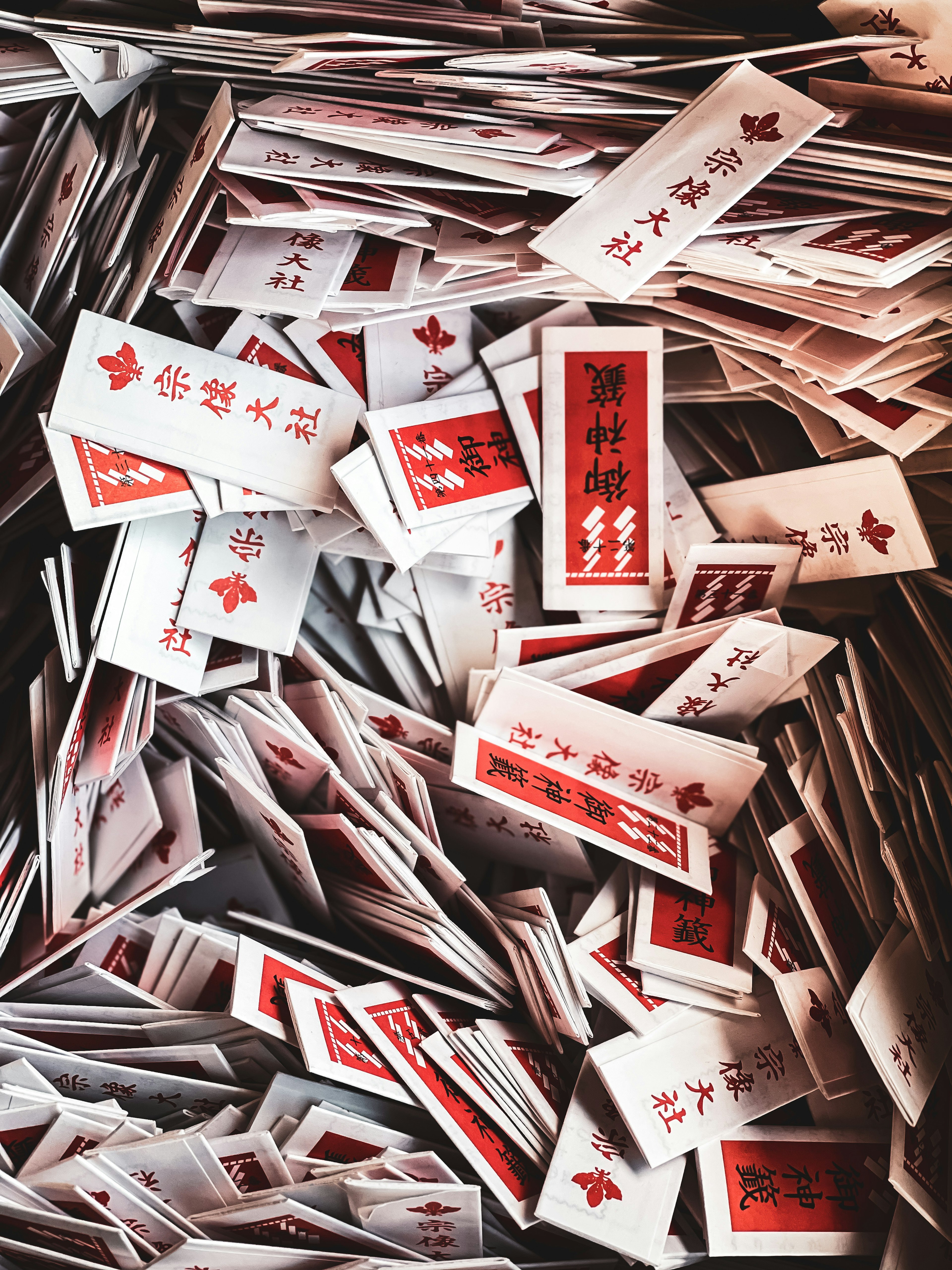 A pile of white slips with red text scattered across the surface