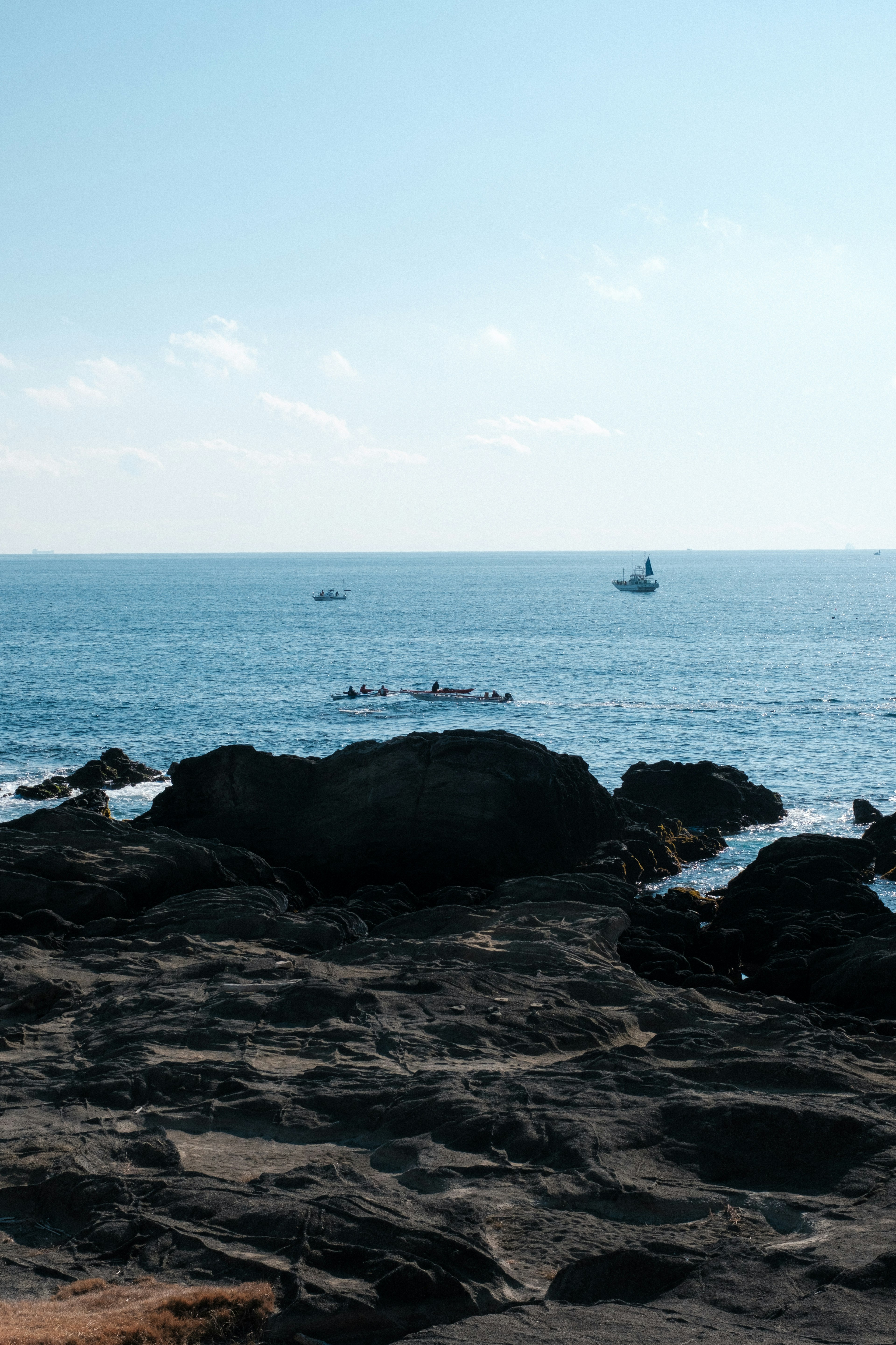 青い海と岩の風景 いくつかのボートが遠くに見える