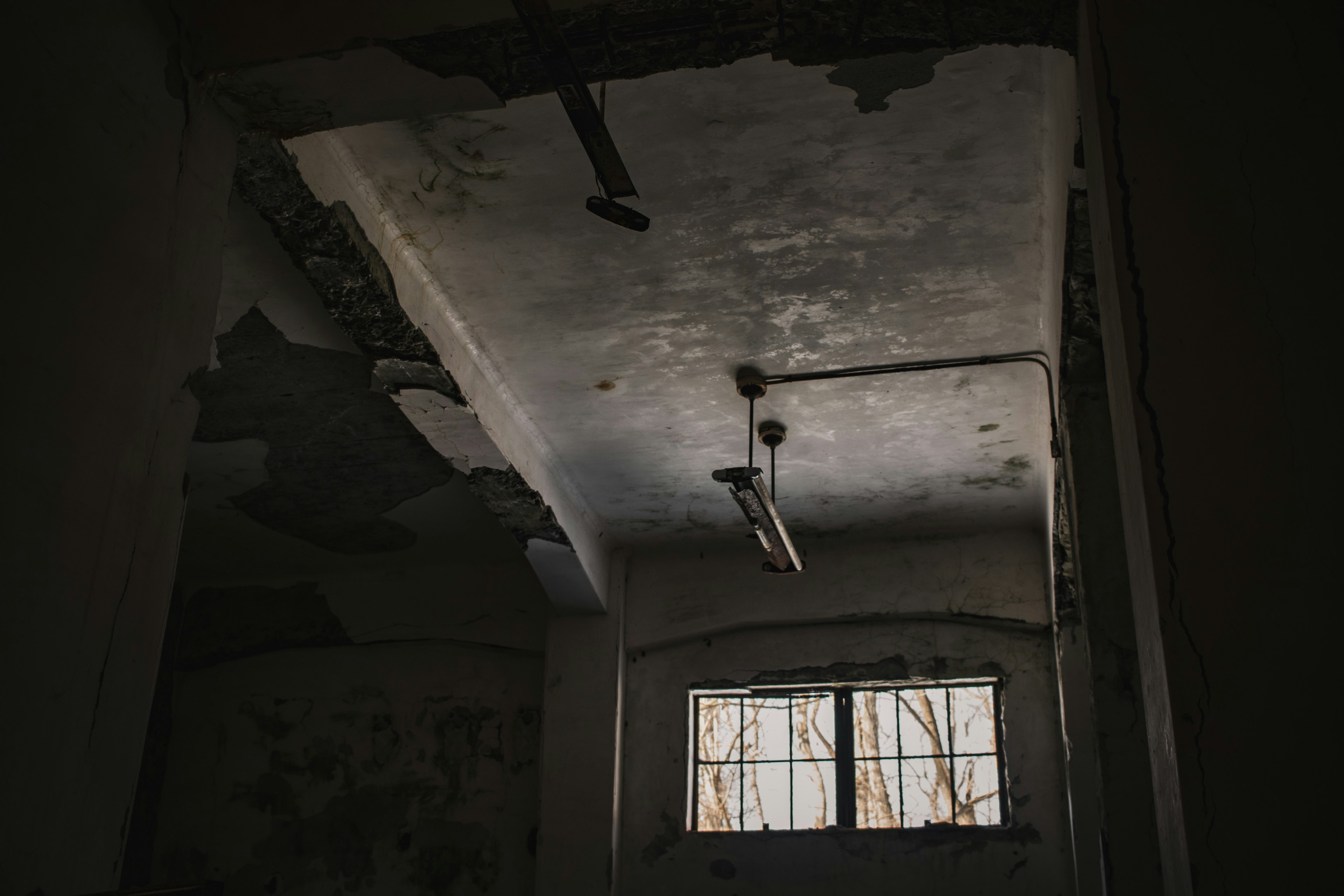 Image d'une pièce sombre et abandonnée montrant le plafond et la fenêtre