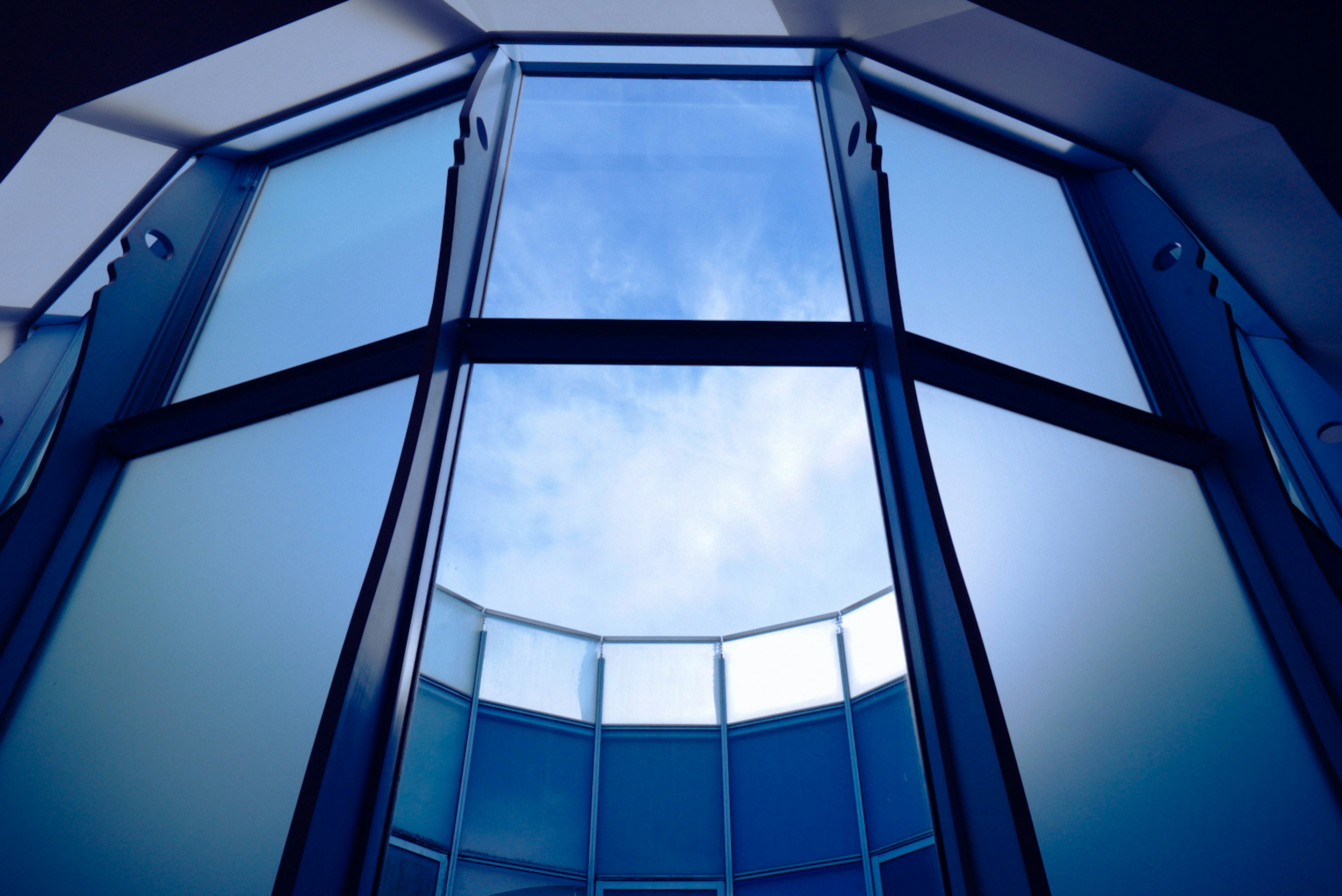 Interior view of hexagonal glass window with a blue sky