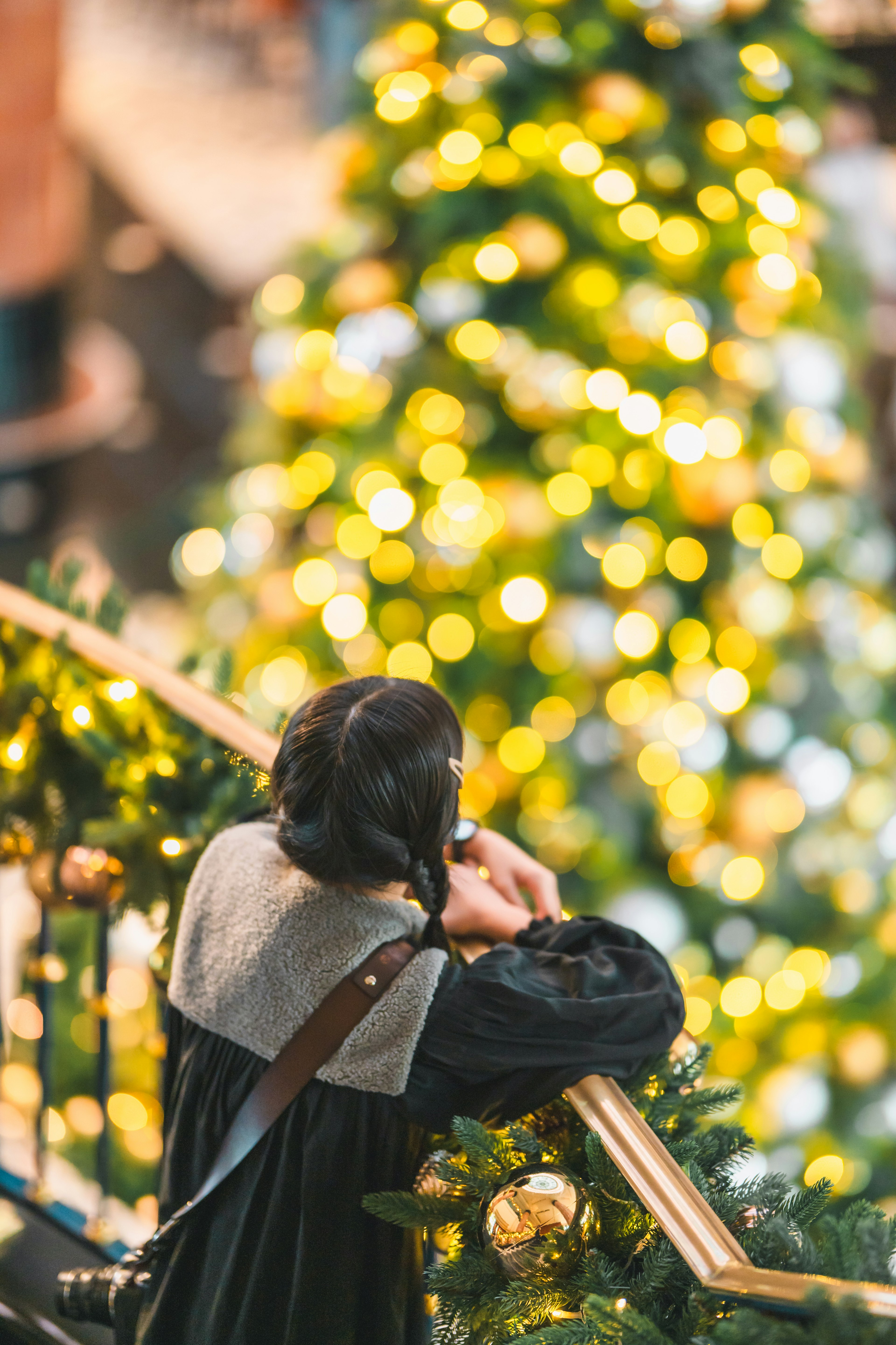 Femme réfléchissant devant un sapin de Noël