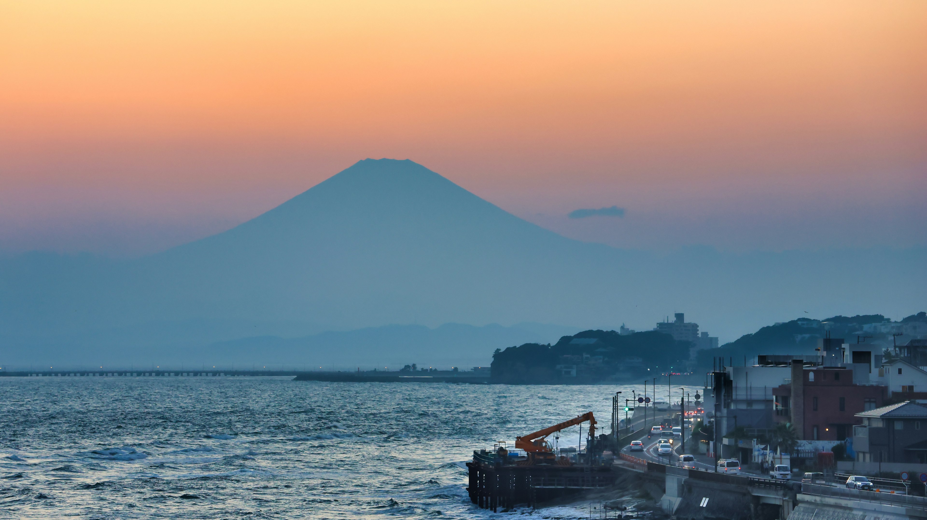 Monte Fuji silhouettato contro un tramonto sull'oceano