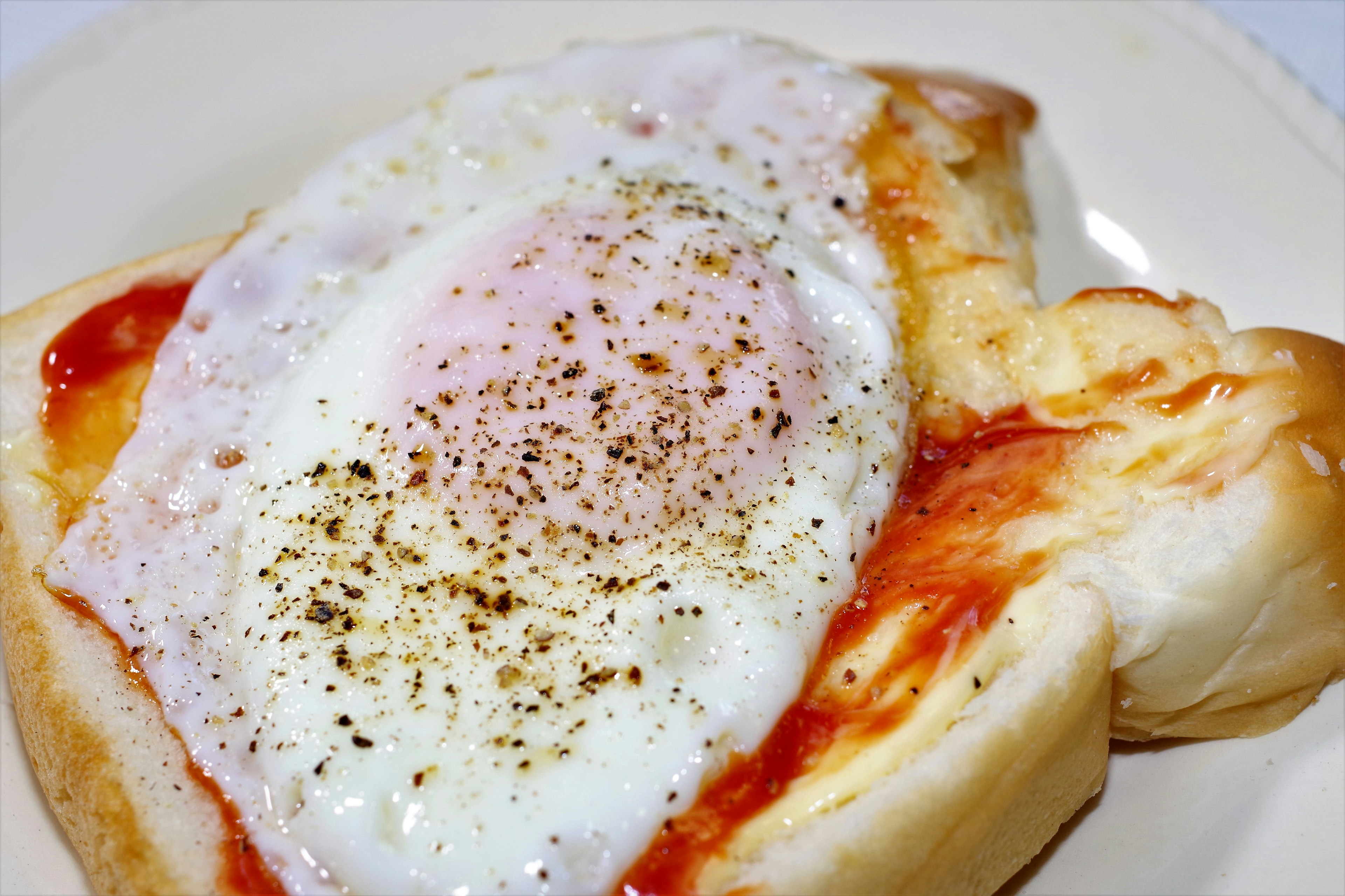 Toast topped with a fried egg and ketchup