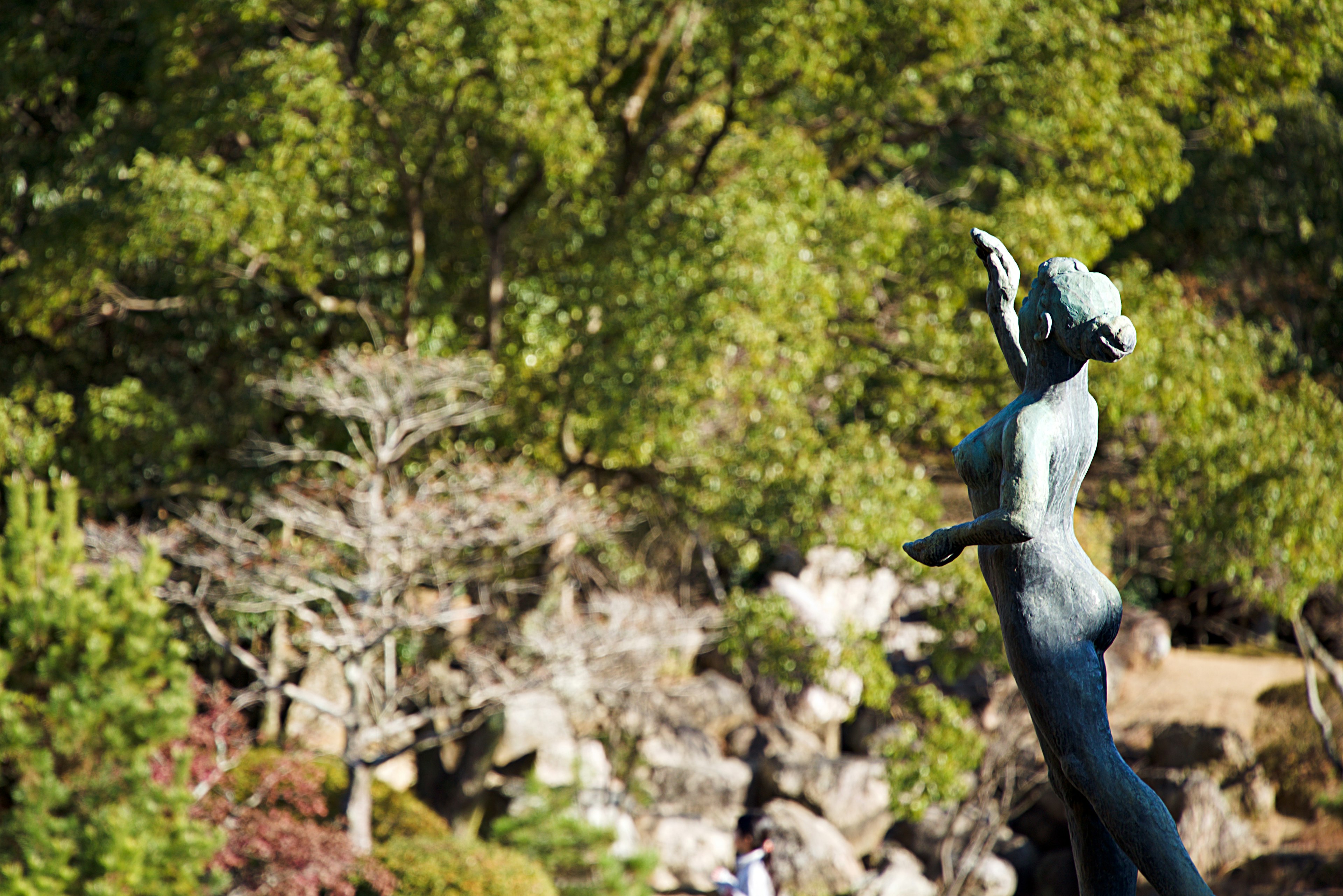 Statua in bronzo di una donna che si erge nella natura