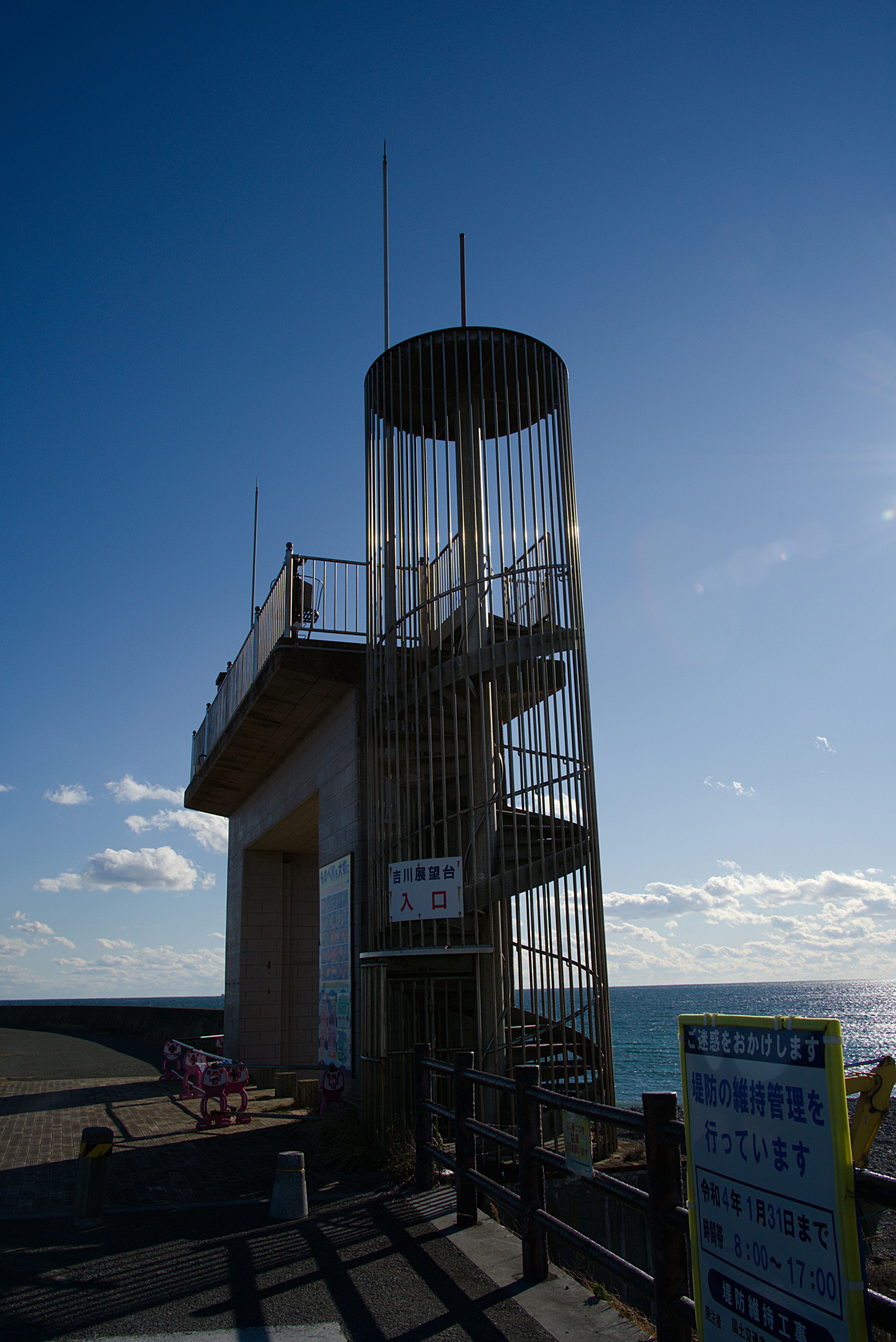 Observation tower with spiral stairs by the seaside and blue sky