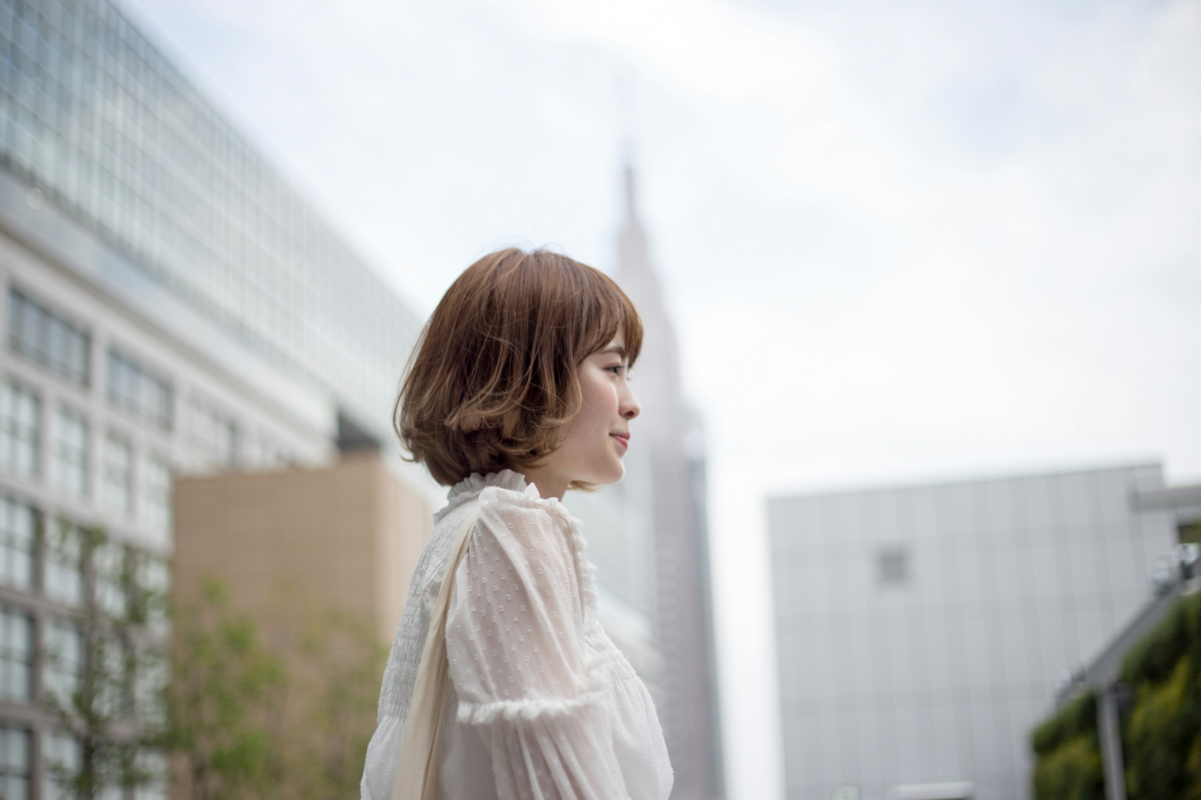 A woman standing with a cityscape in the background