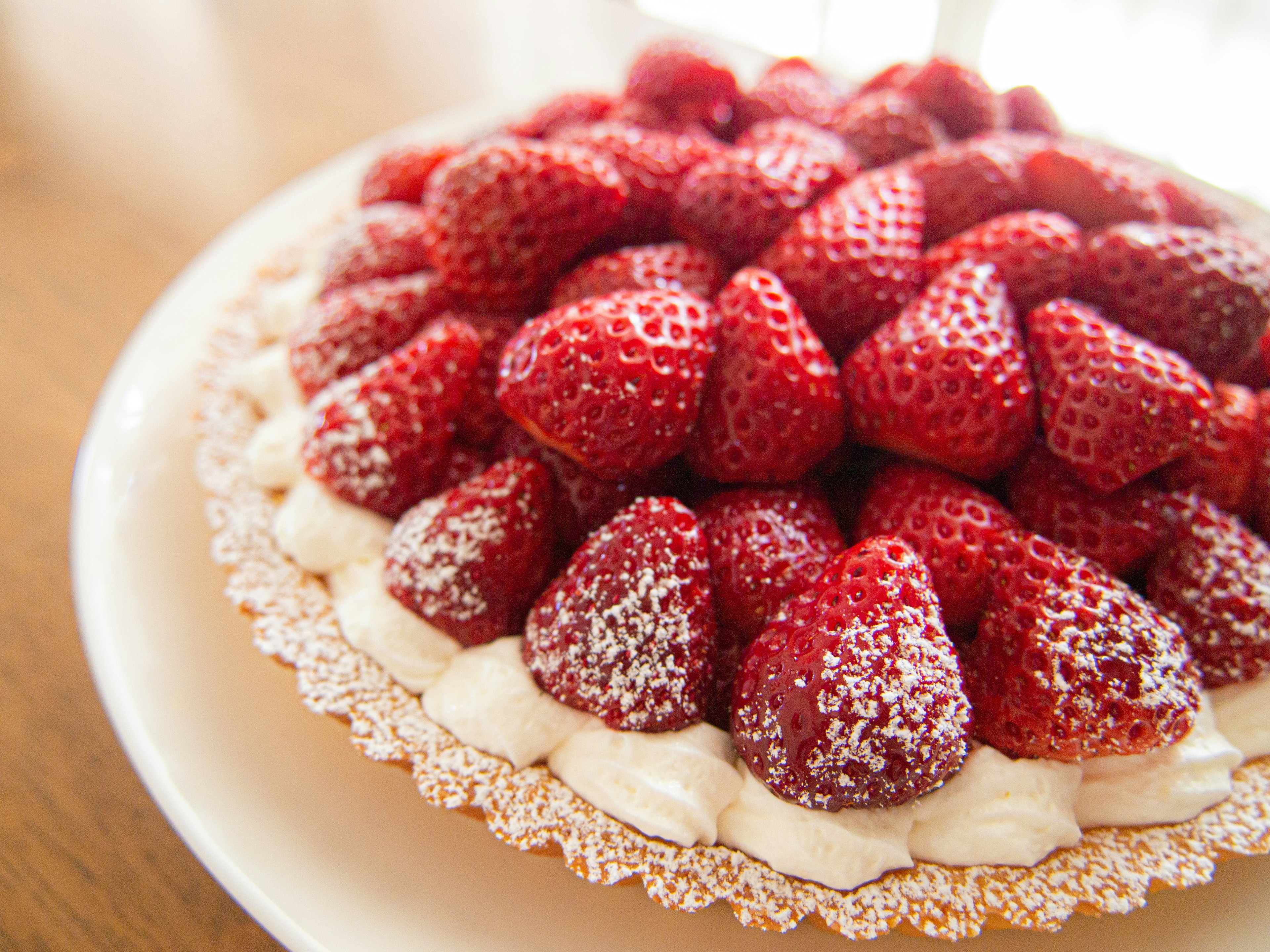 A tart topped with fresh strawberries and powdered sugar