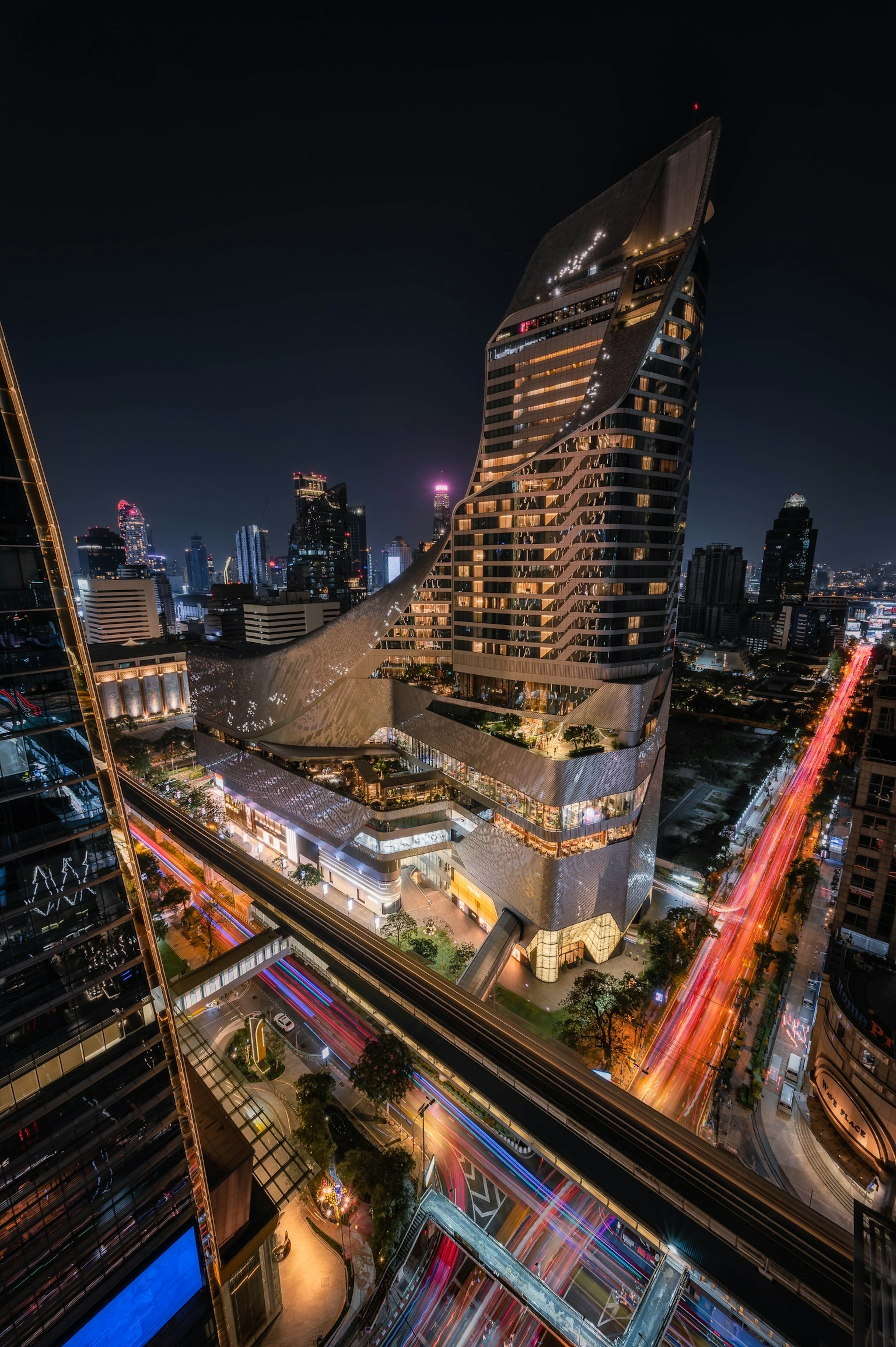 Night cityscape featuring a modern skyscraper and flowing traffic